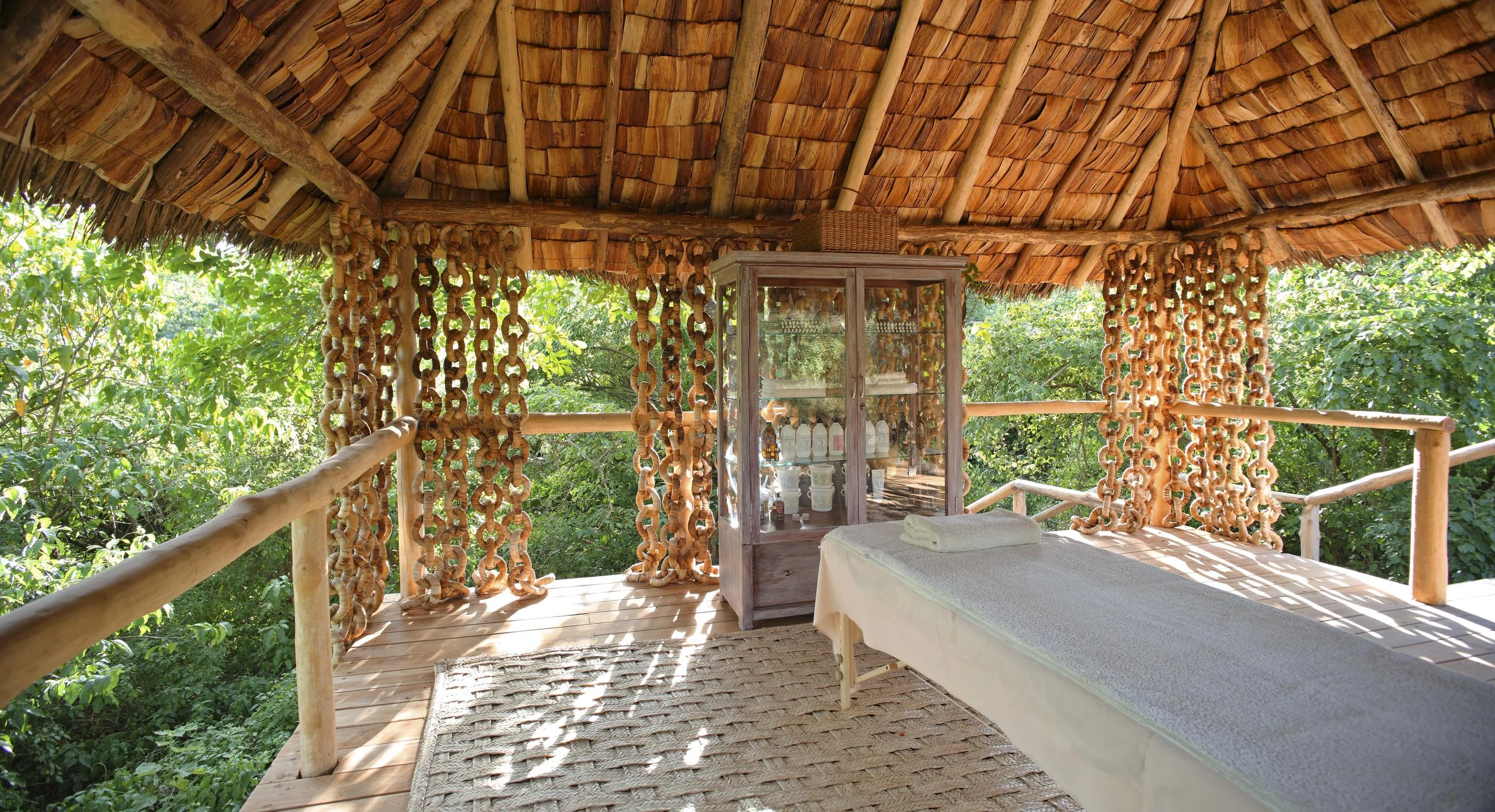 A treehouse bathroom with a bath and stone walls