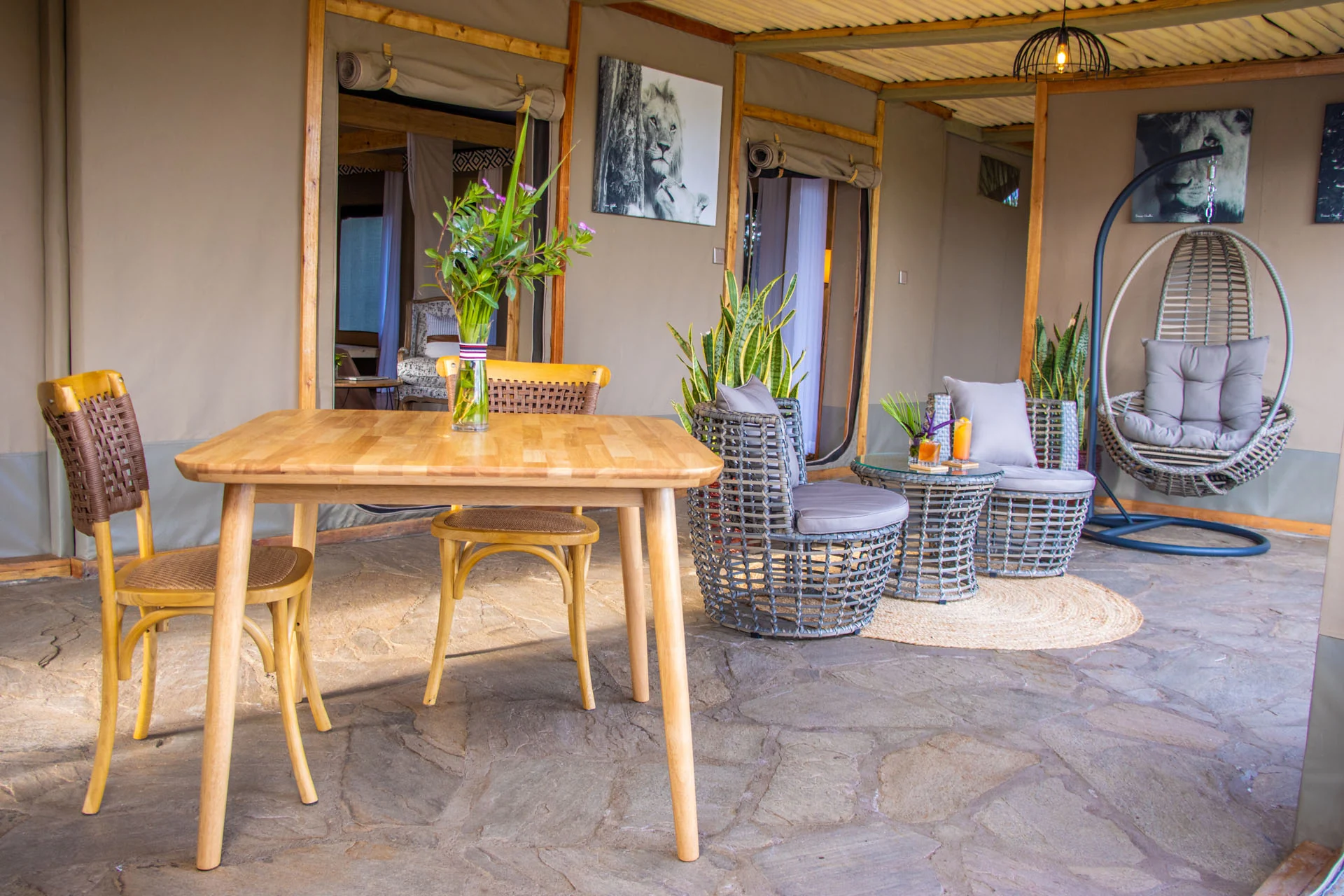 A dining table and hanging chairs on a veranda