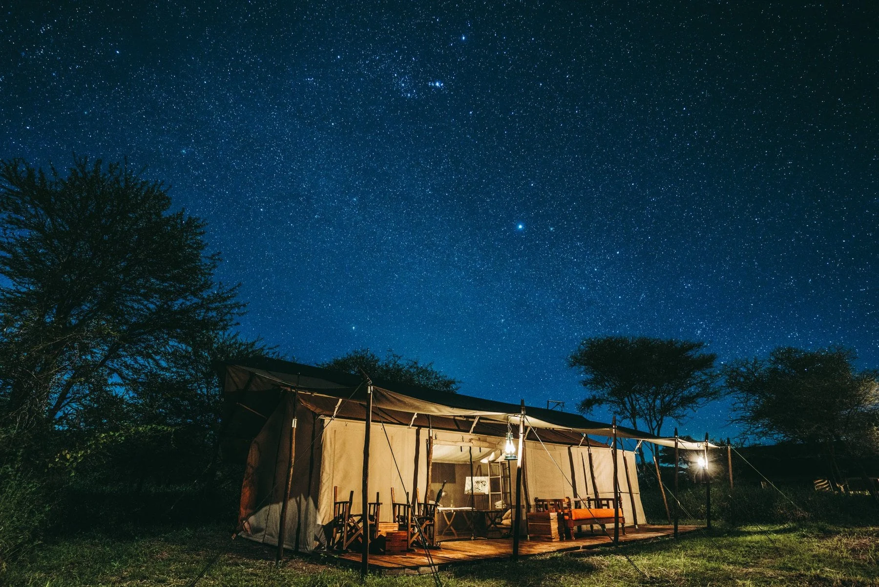 A guest tent lit under the night sky