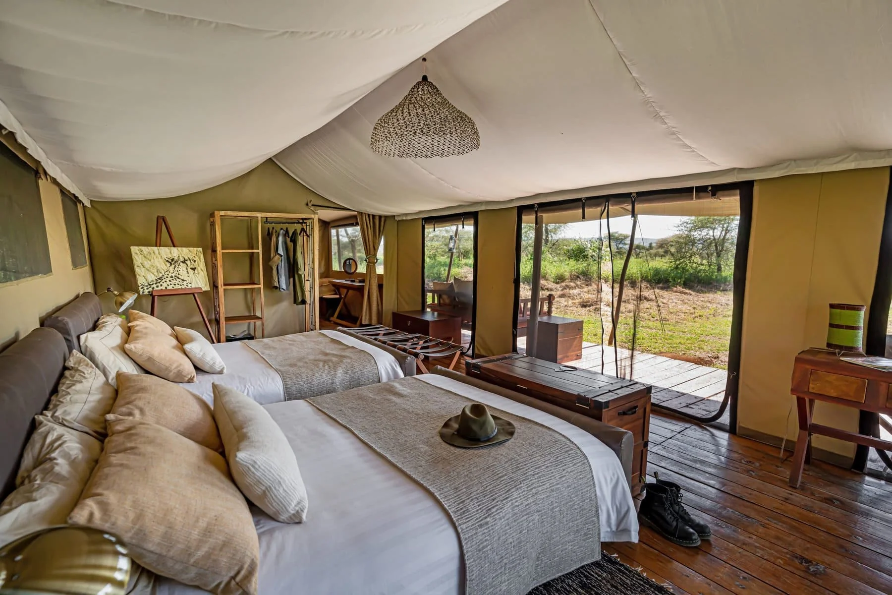 A tent bedroom with the front open to the plains