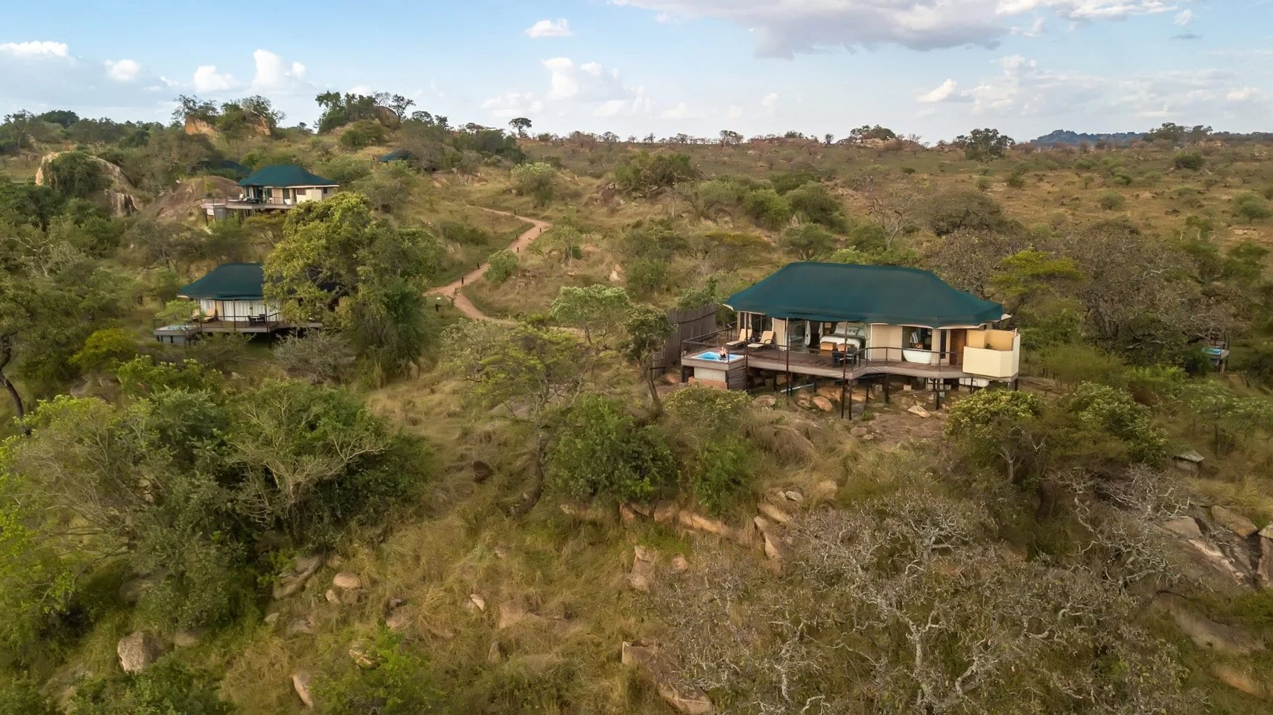 The suites among the trees on the hillside, from the air