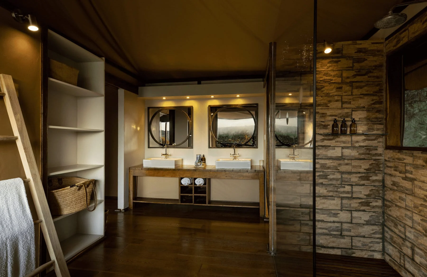 A bathroom with twin basins and stone walls