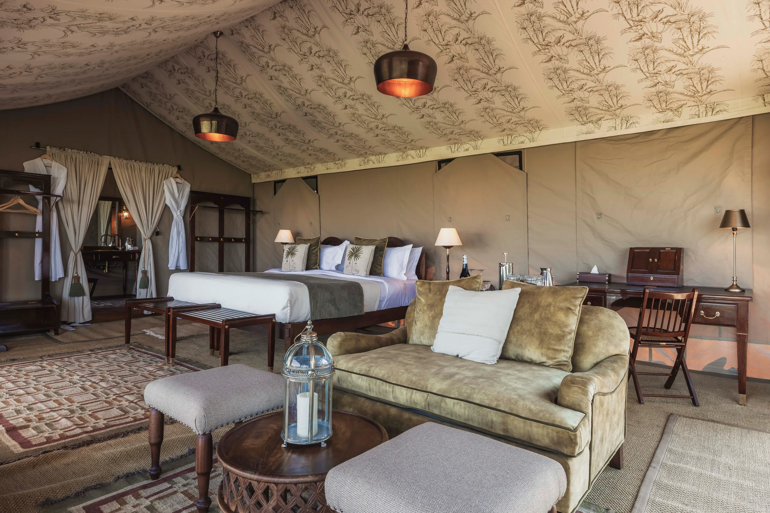 A bed and sitting area inside a safari suite at Little Elephant Pepper Camp