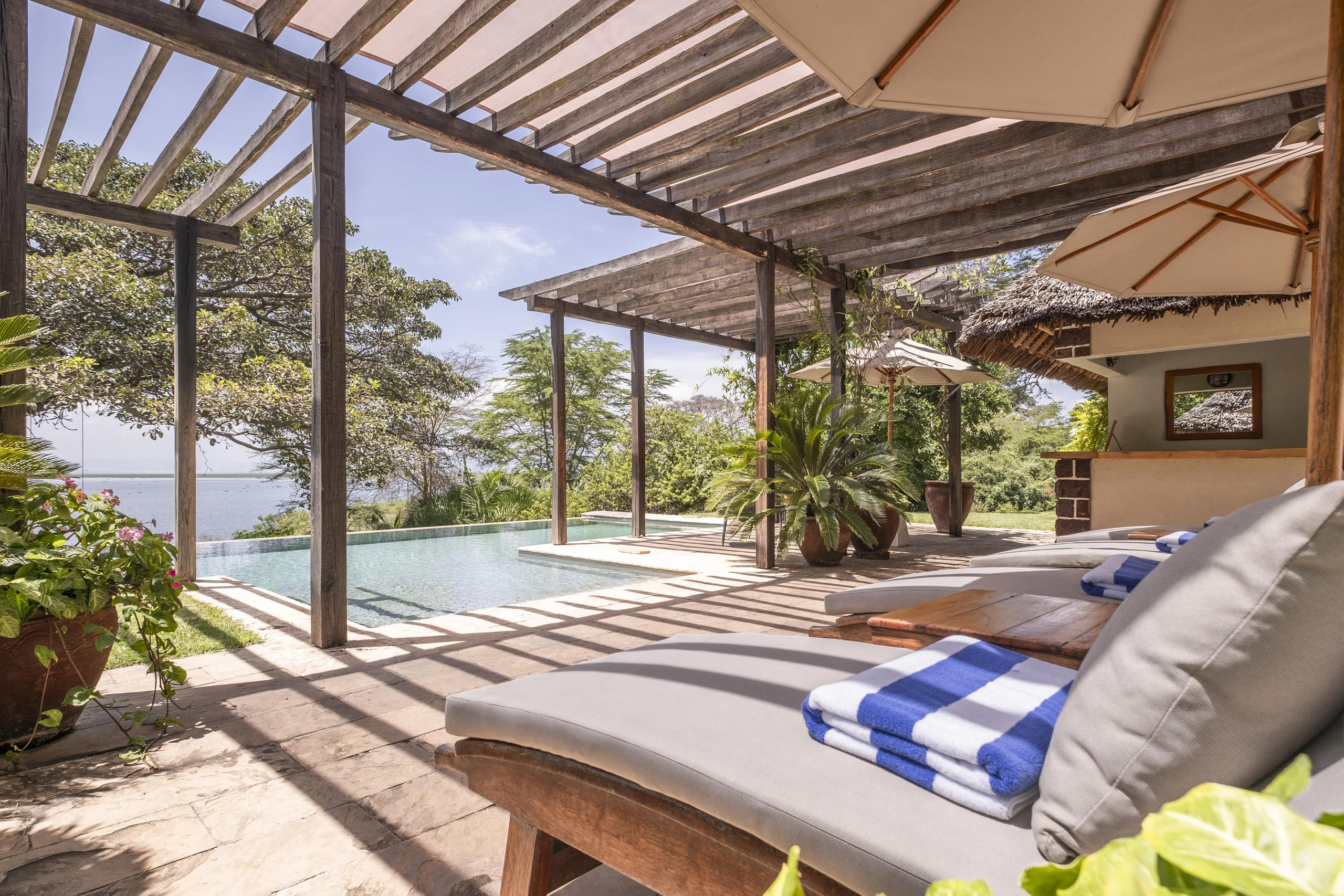 Loungers under a pergola beside the pool