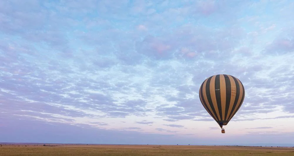 A hot air balloon over the plains at dawn