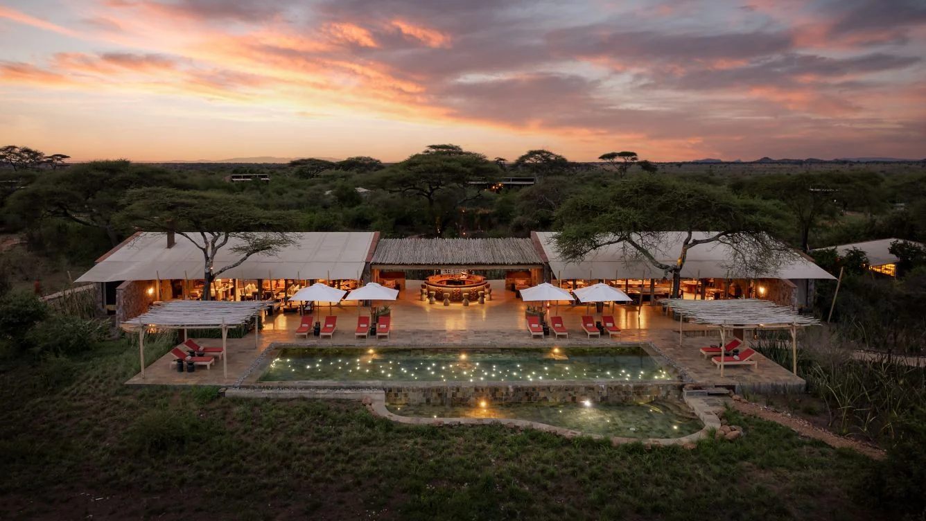 The camp and its pool among the acacias at sunset