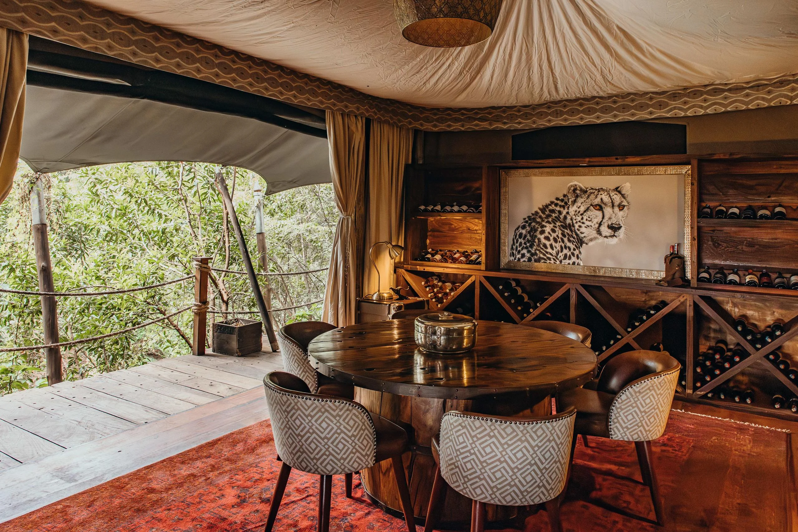 A tent with a dining table and a wine rack