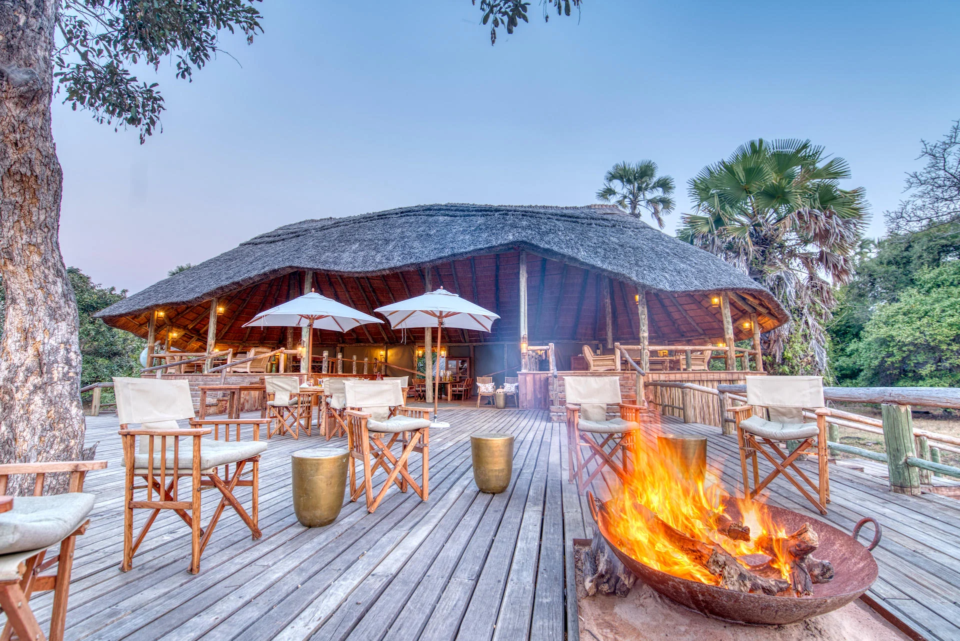 The main tent's deck with a fire lit at dusk