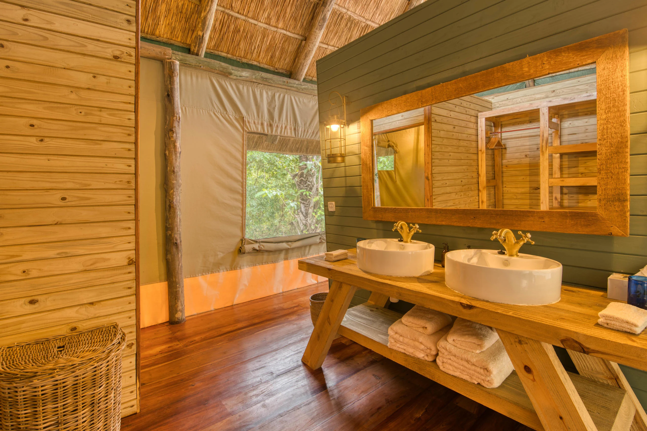 A bathroom with twin basins and timber walls
