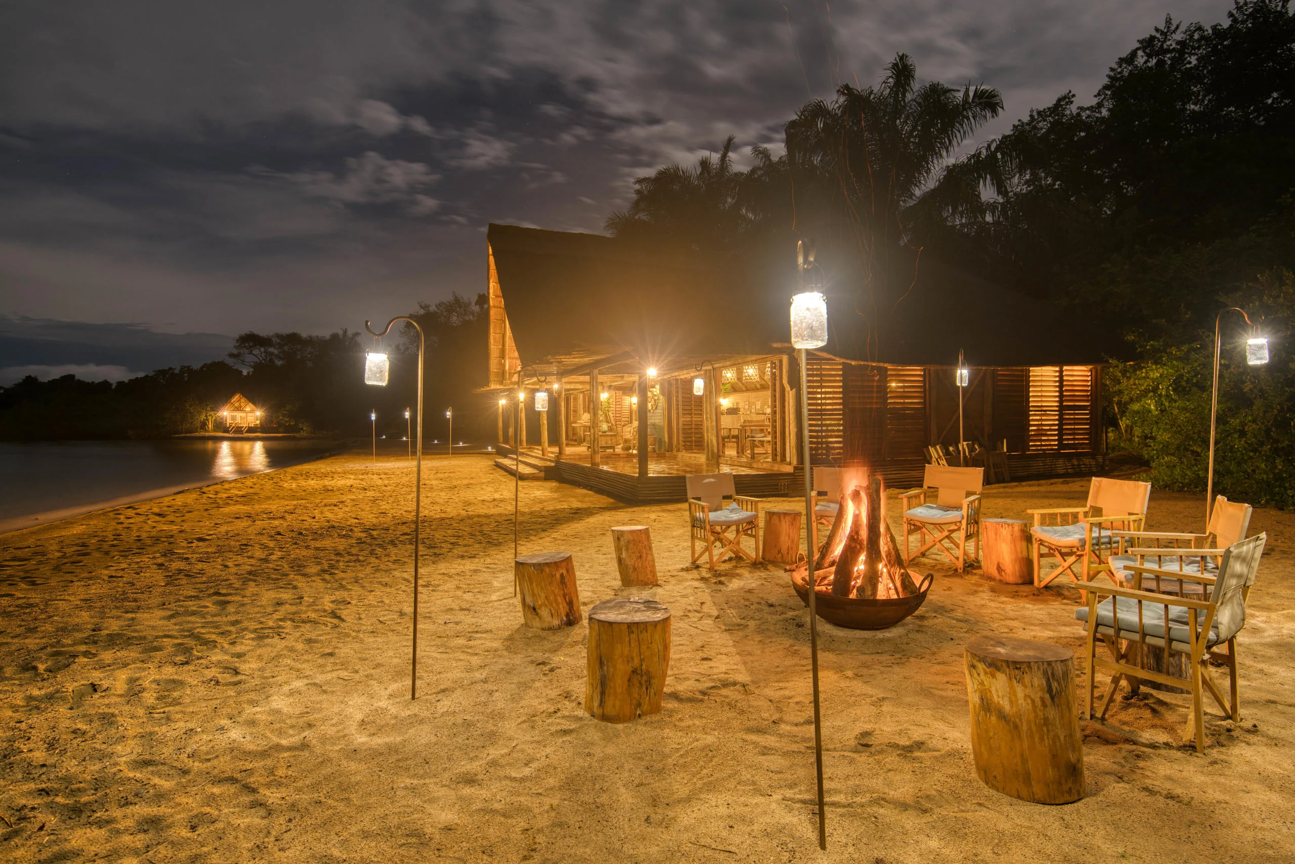 Chairs around the fire on the beach at dusk
