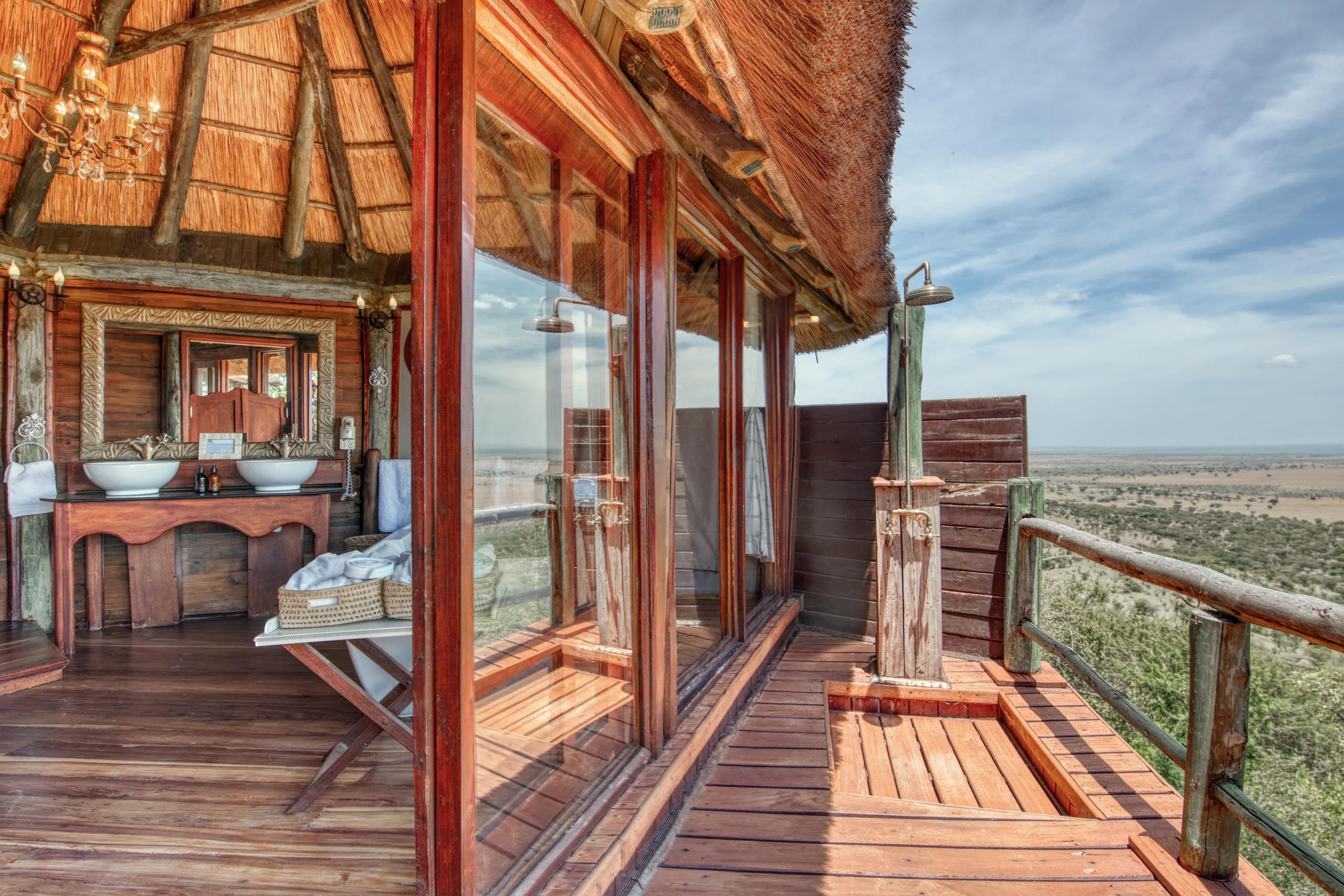 A deck with a chair and a bathroom beyond