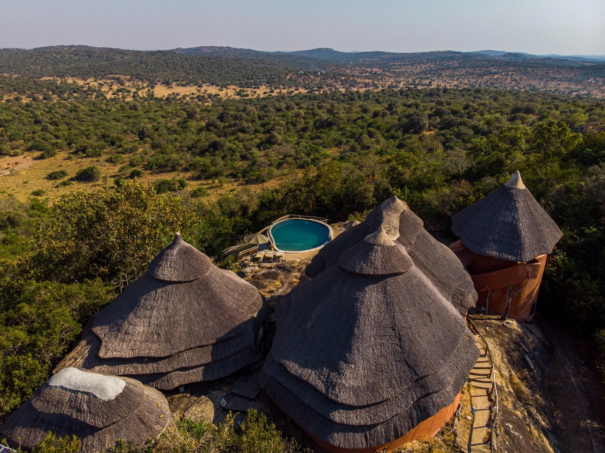 The thatched bandas and pool on the hilltop, from the air