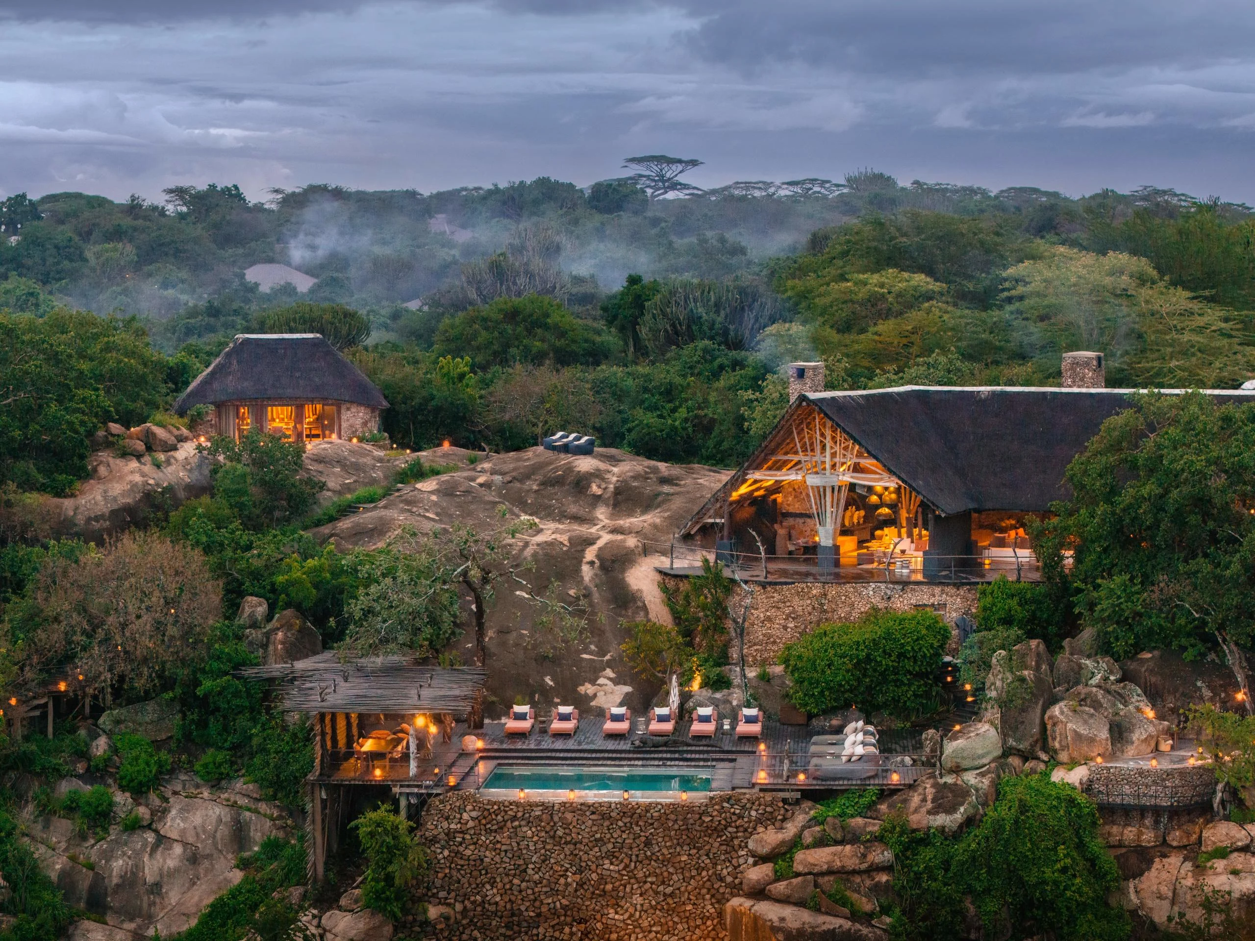 The lodge among the trees and rocks at dusk
