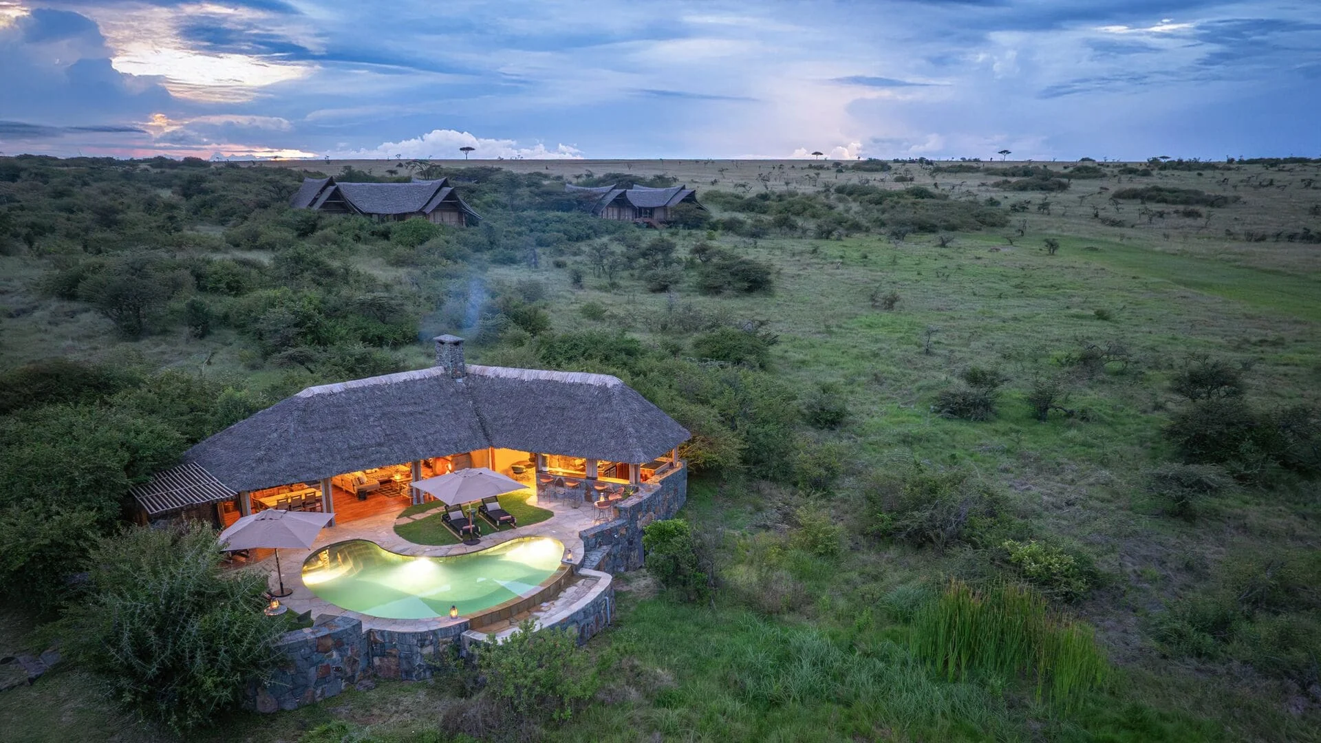 The camp and its pool on the plains at dusk, from the air
