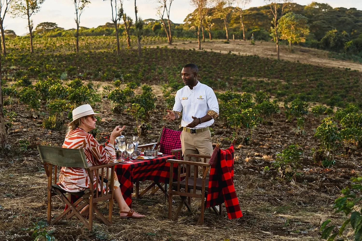 Guests at a table in the garden with a member of staff