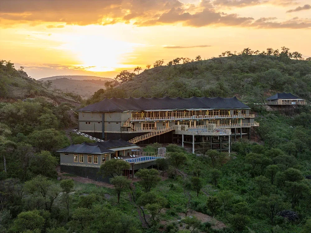 The lodge on its hillside at sunset, seen from the air