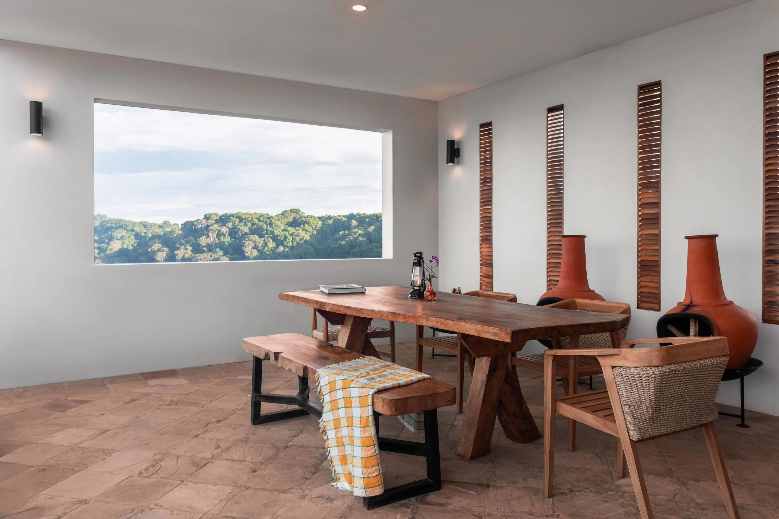 A dining area with a timber table and a window onto the crater