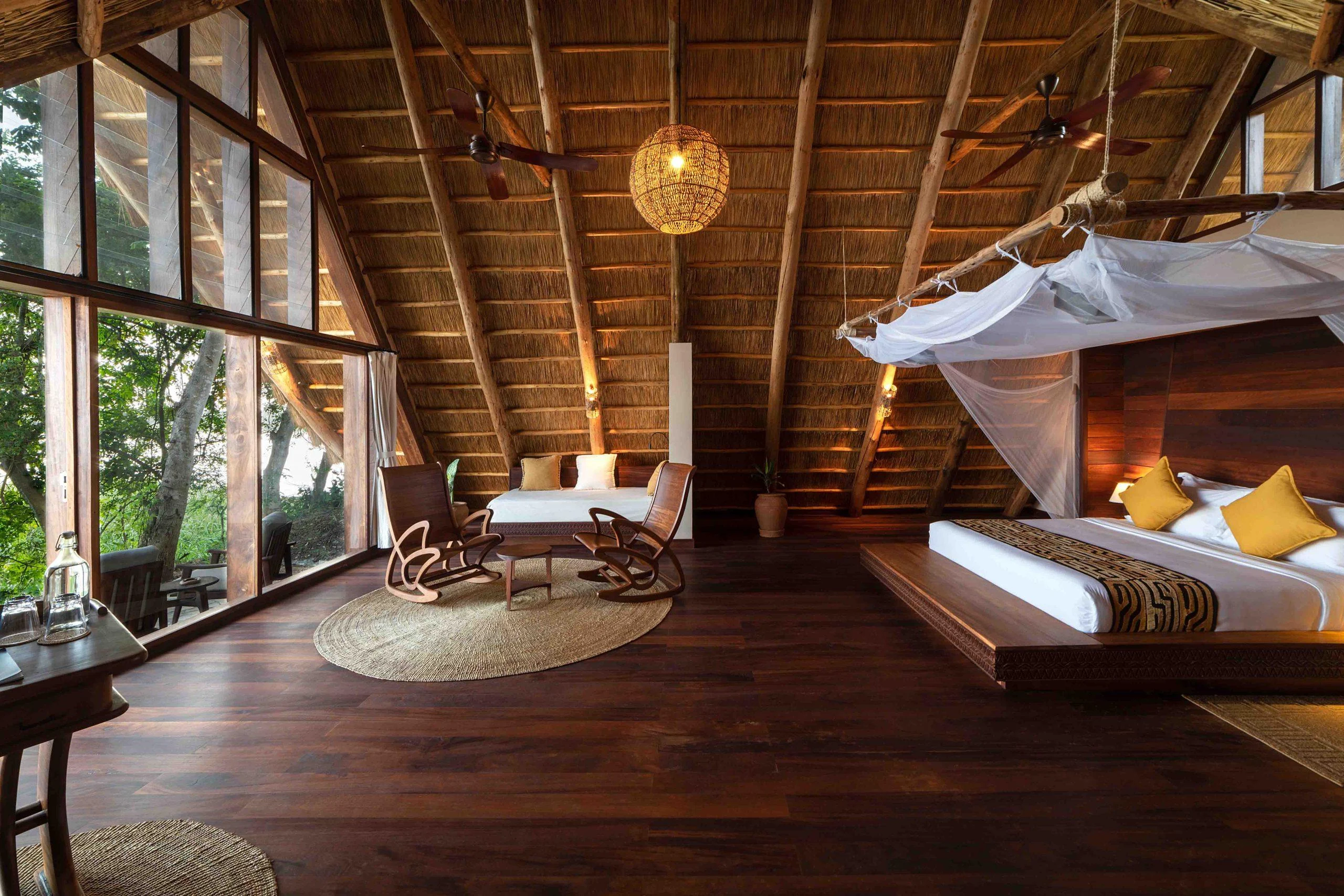 A room with a draped bed and doors onto the deck