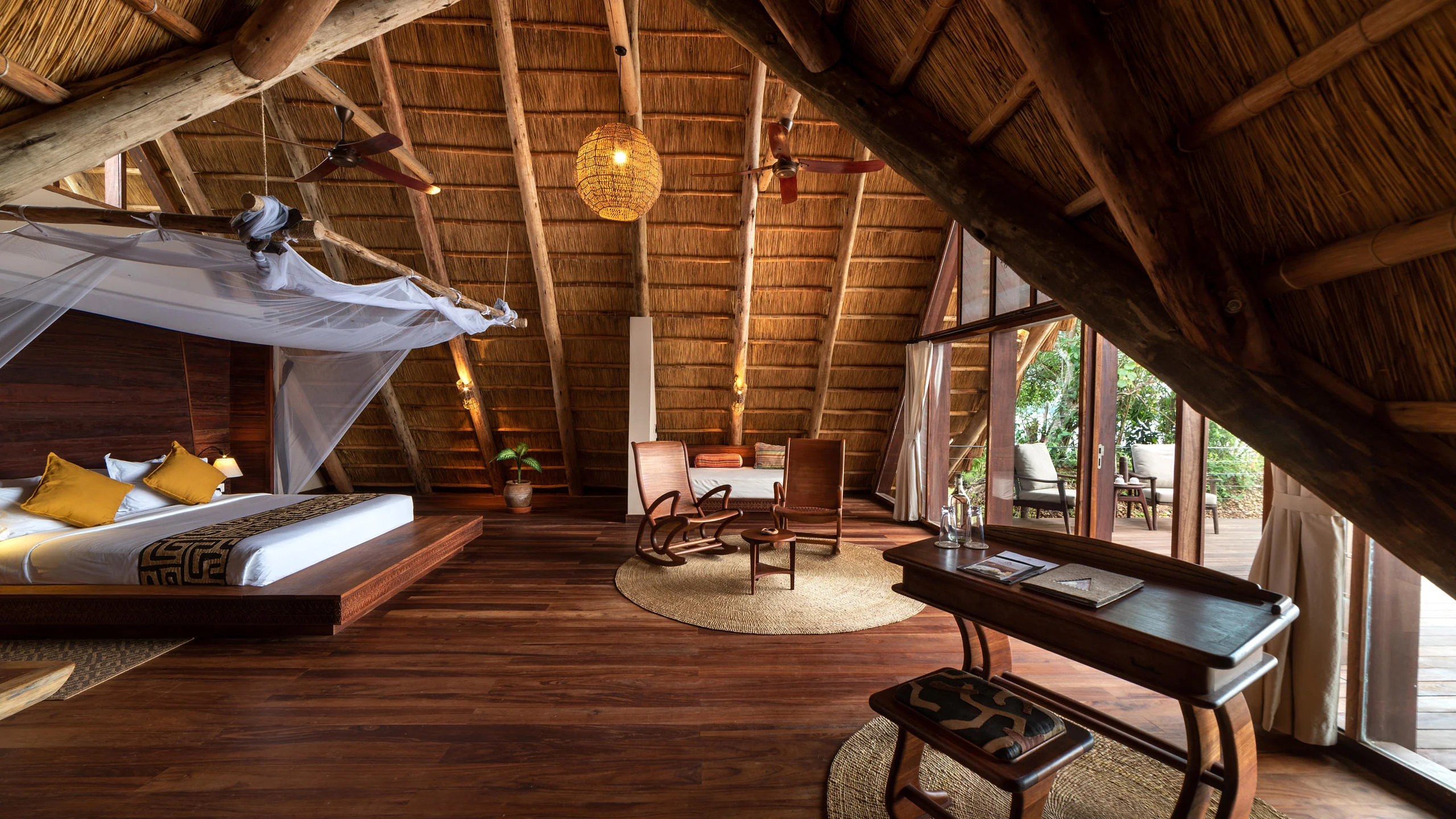 A bedroom with a draped bed and timber floors