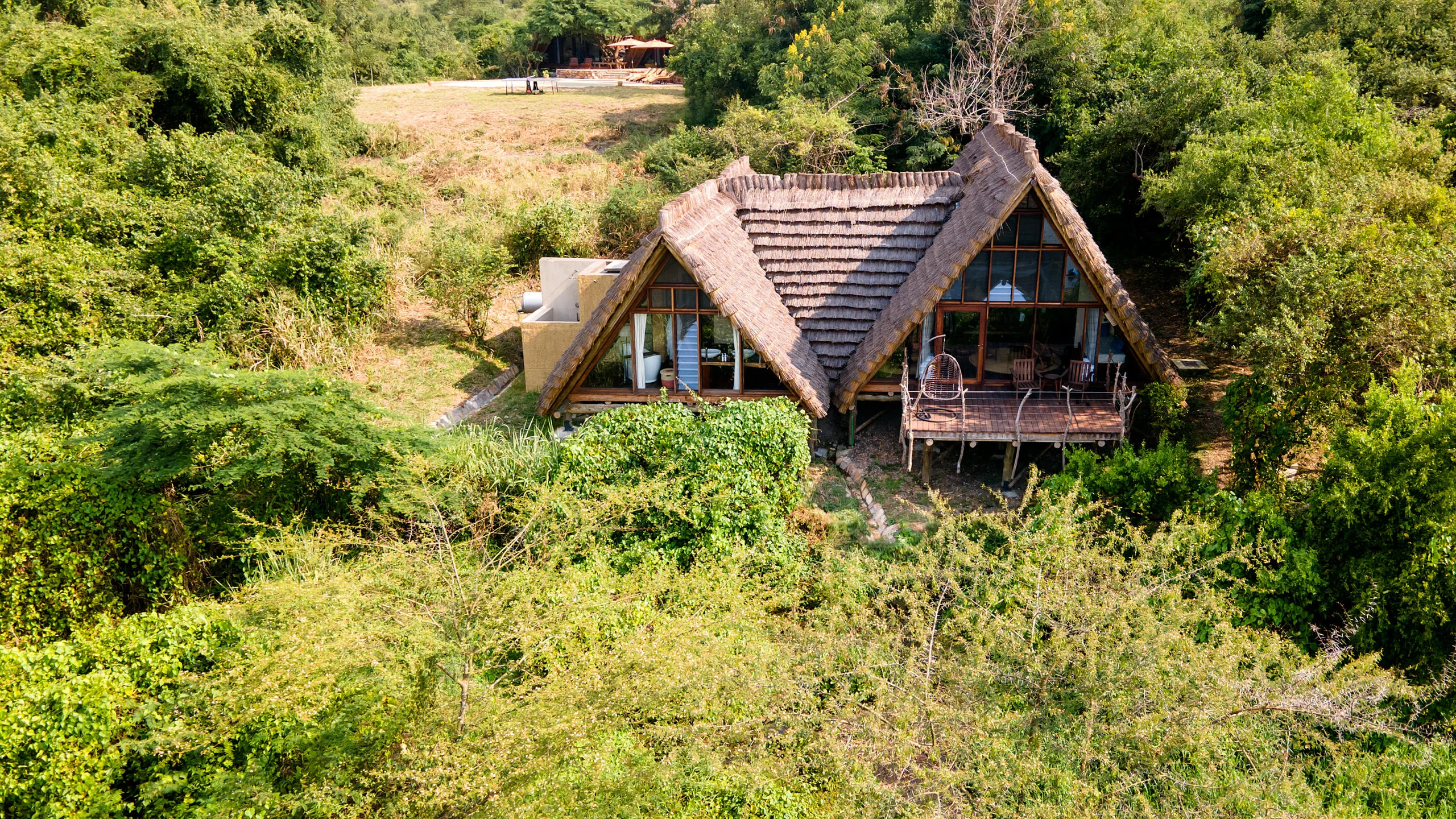 A thatched banda on the riverbank among the trees