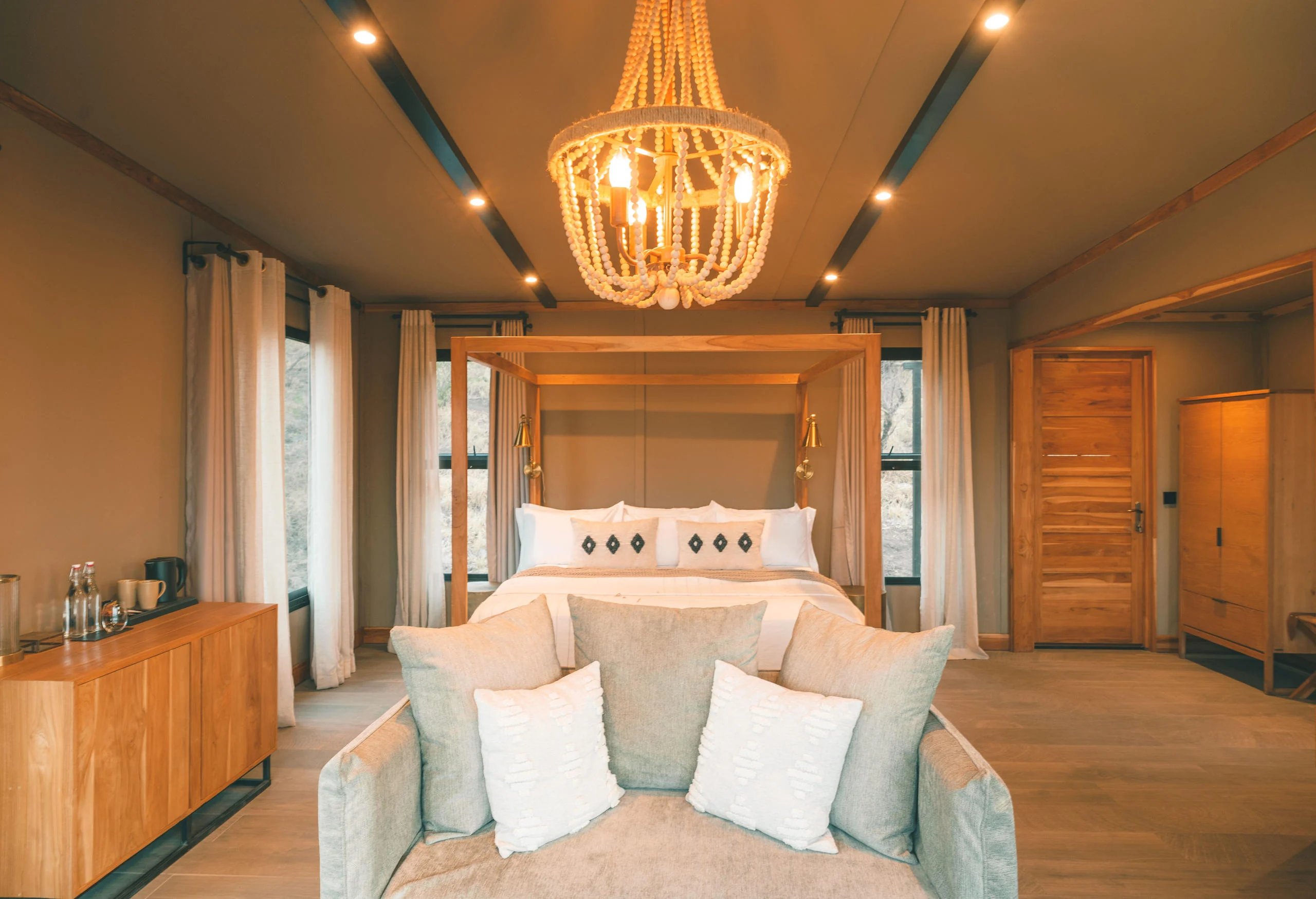 A bedroom with a woven chandelier and a canopied bed