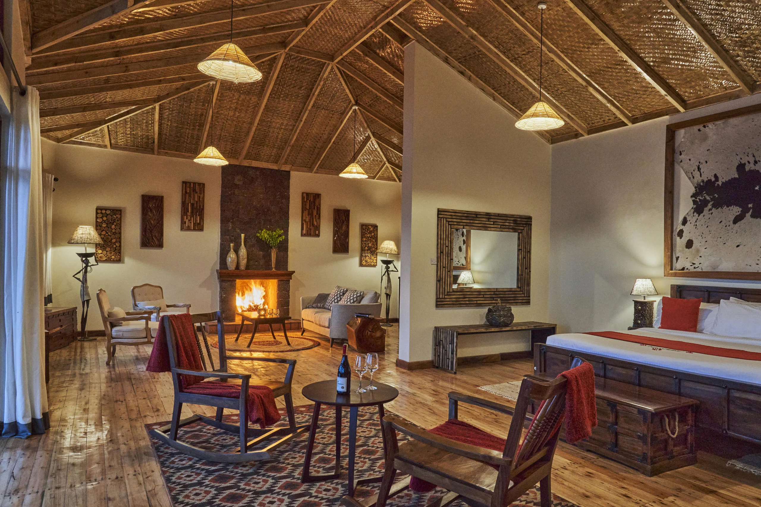 A cottage sitting room with a fireplace and a bedroom beyond