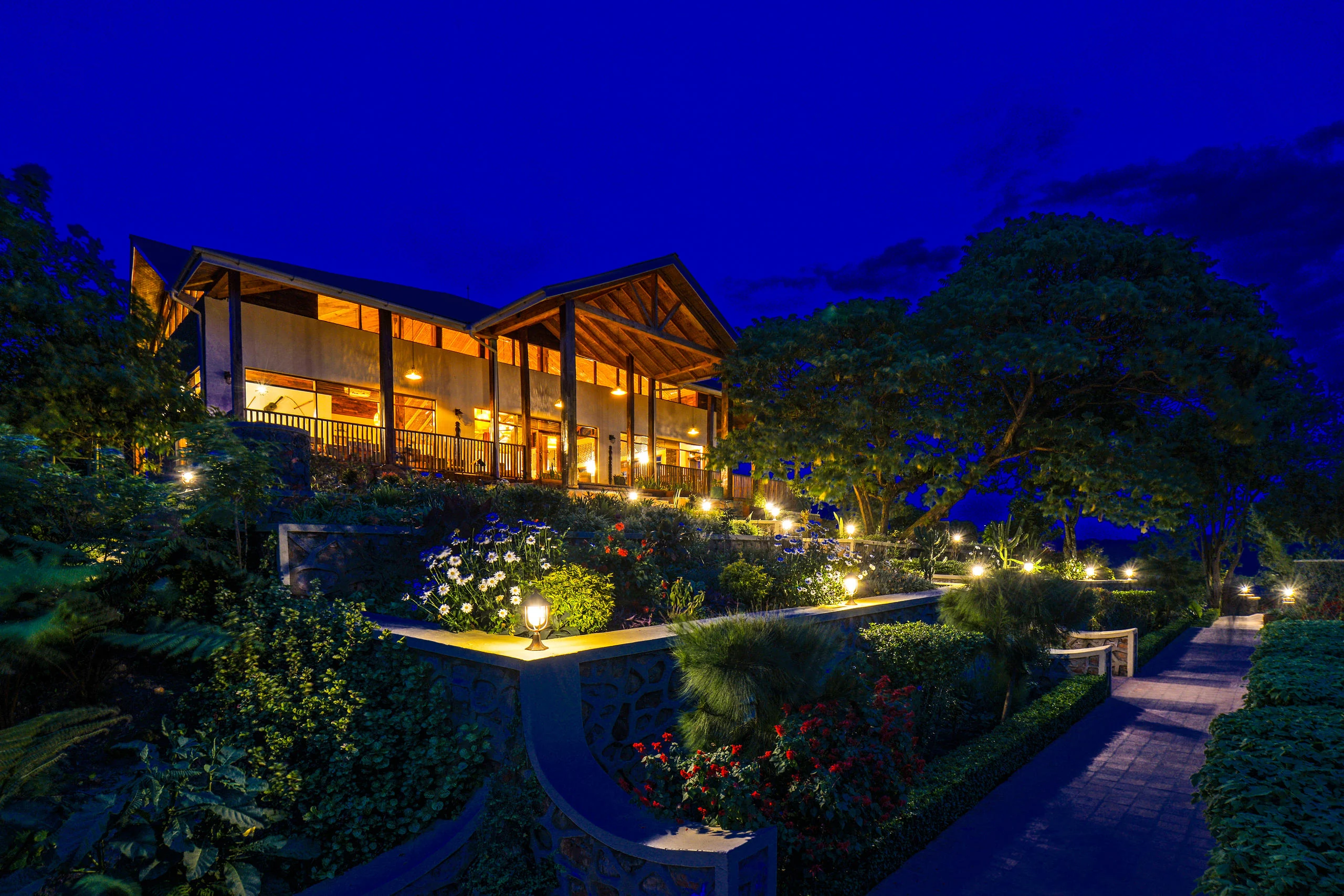 The lodge lit at dusk in its garden