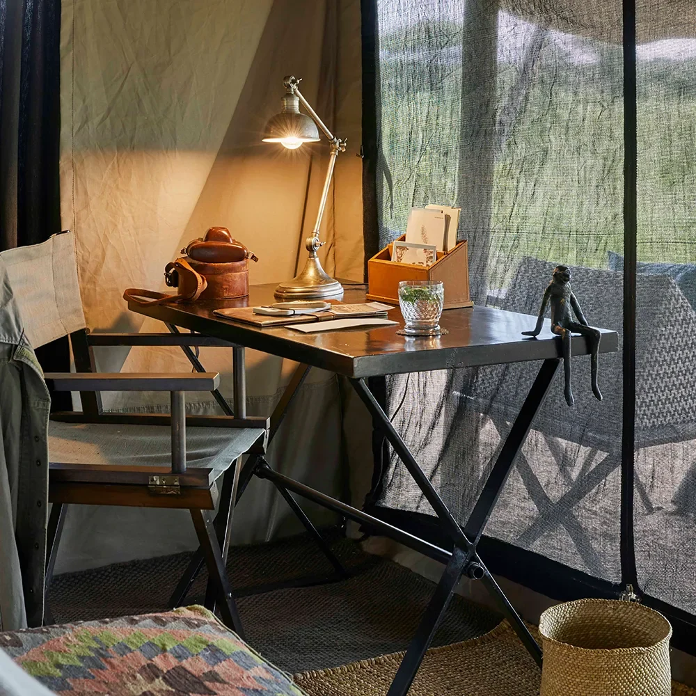 A writing desk in a tent with the plains beyond