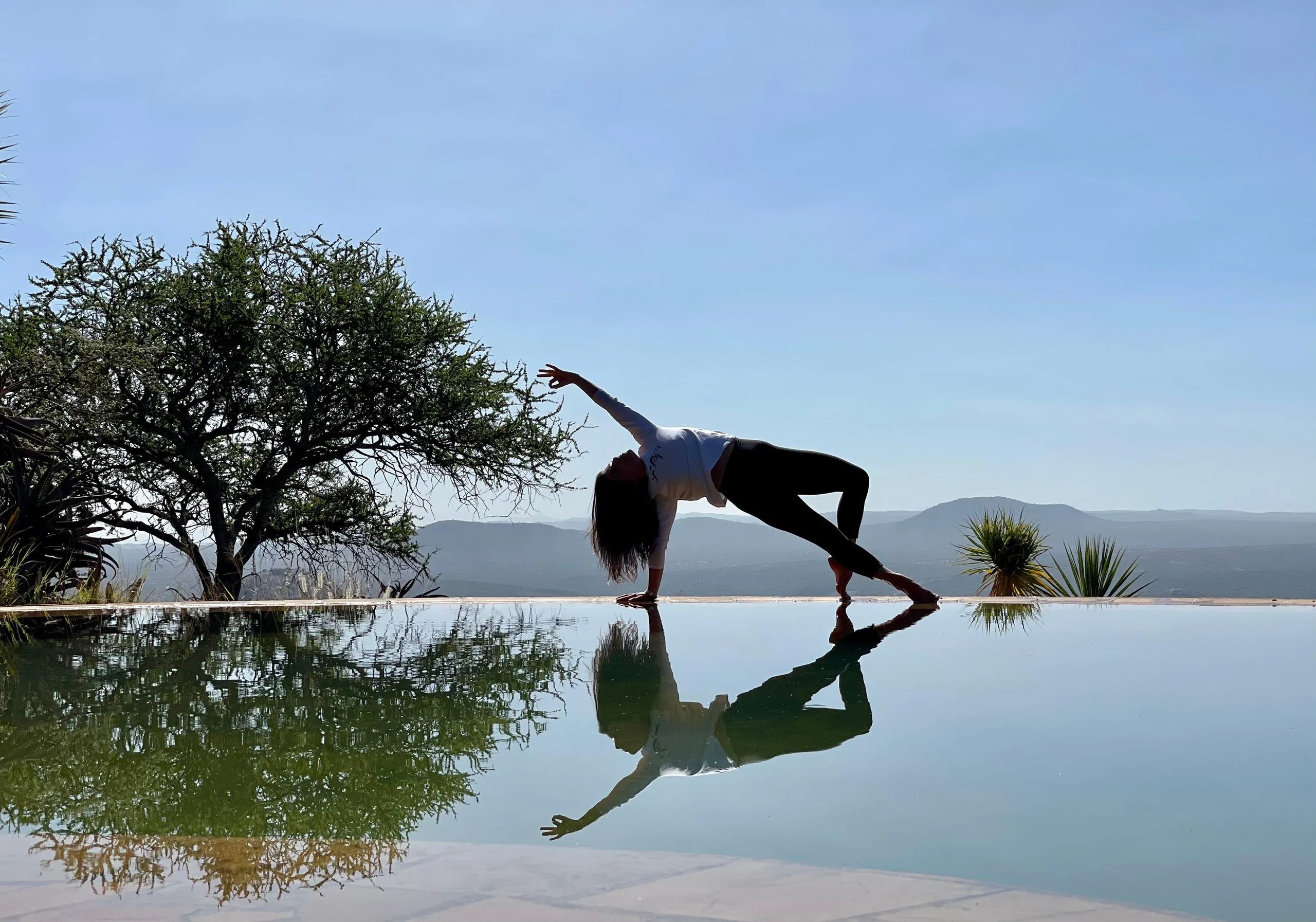 A guest practising yoga beside the infinity pool