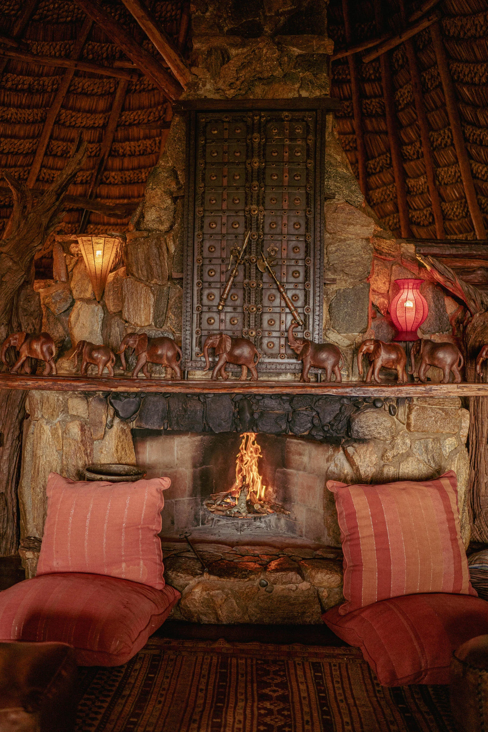 A fireplace with cushions in the sitting room