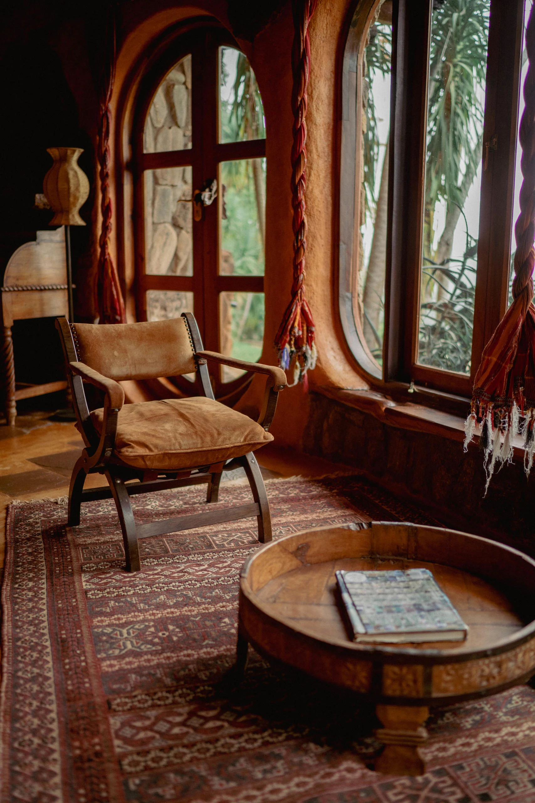 A sitting room with an arched window and armchairs
