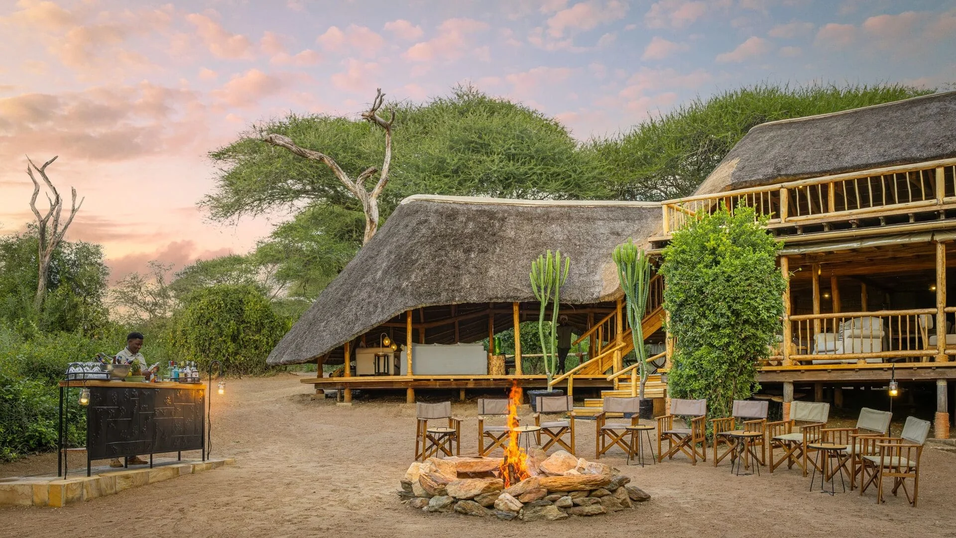 The thatched main building with a campfire in front