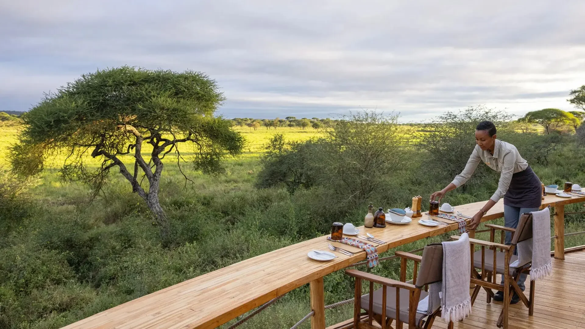 A table being laid on the deck above the plains