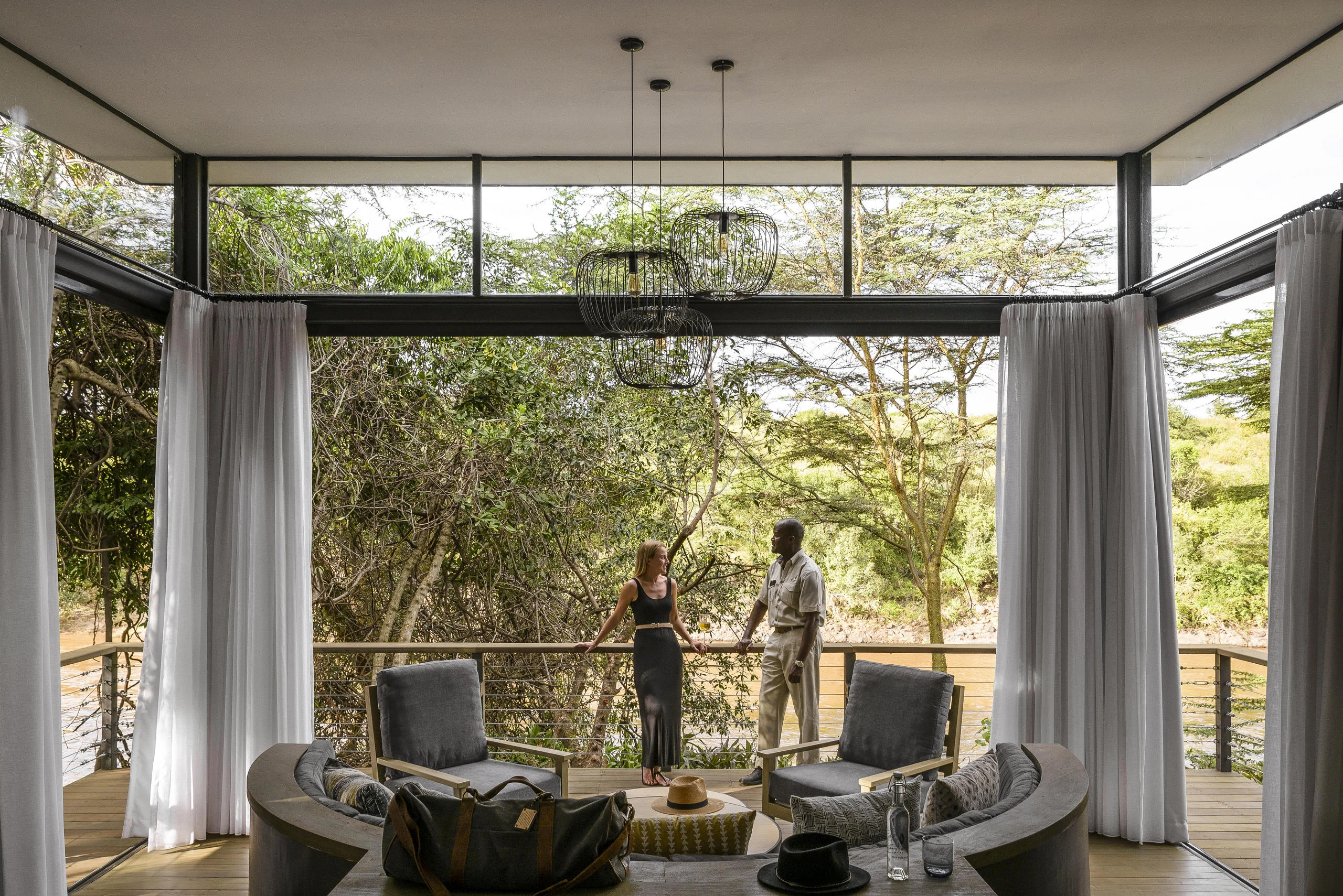 A suite sitting room with glass walls onto the forest