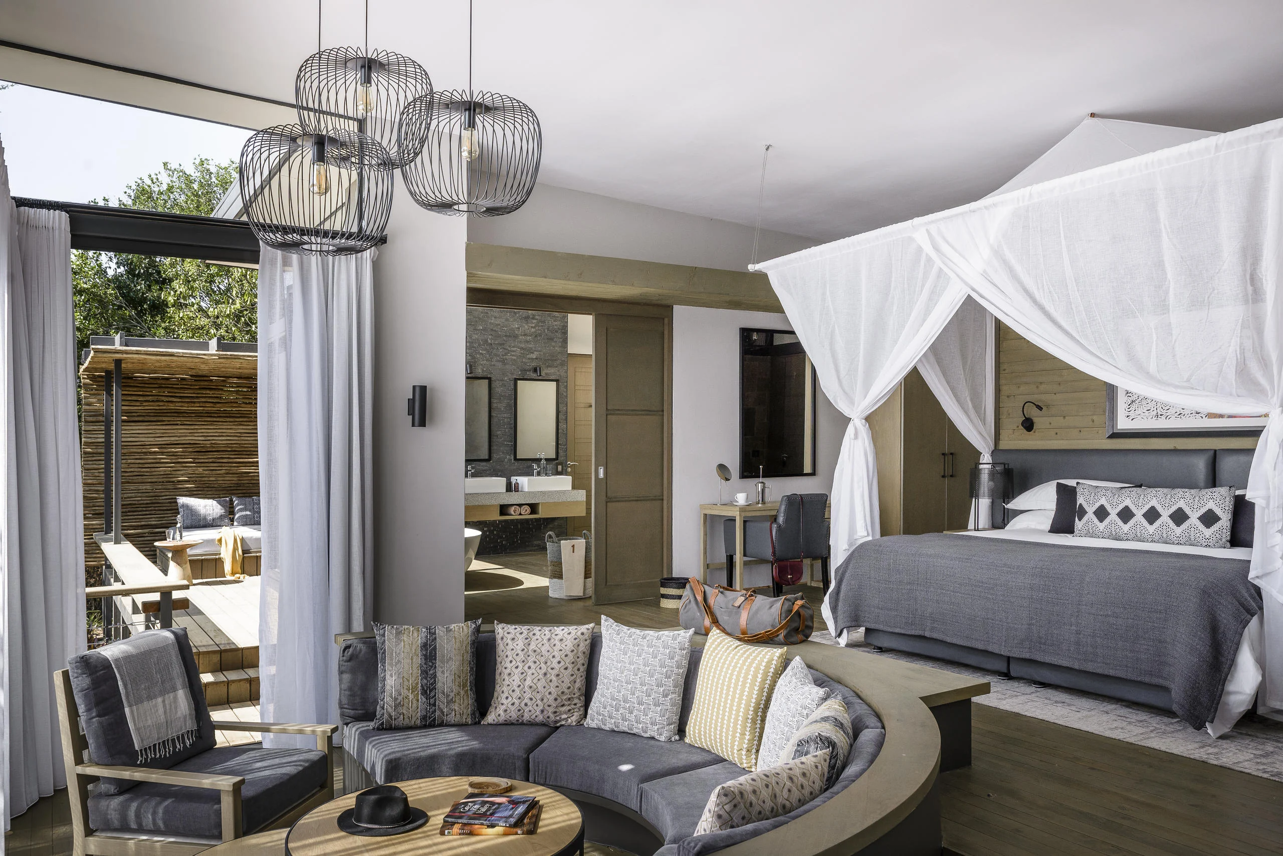 A suite bedroom with a draped bed and a sitting area