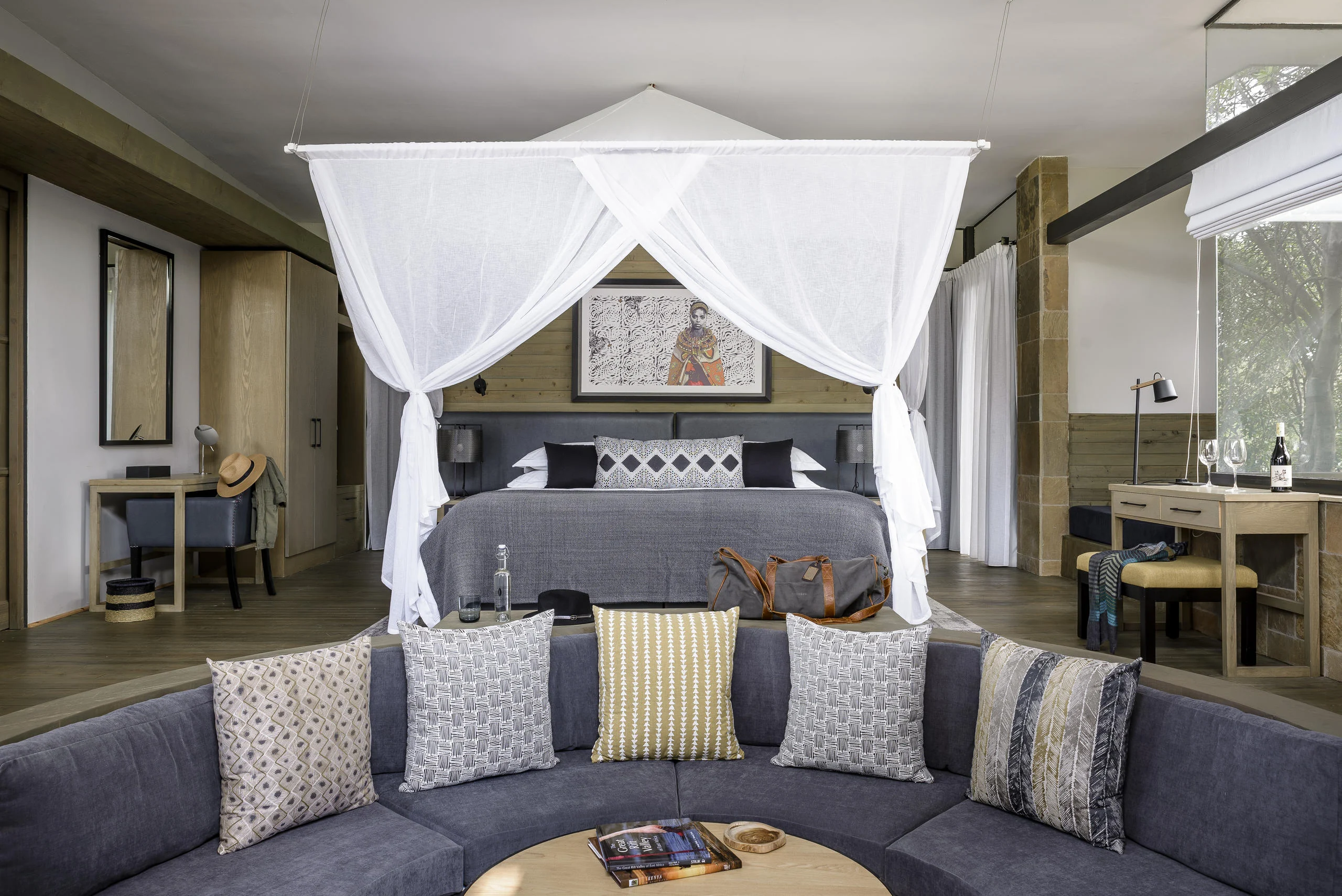 A bedroom with a draped bed and a sofa