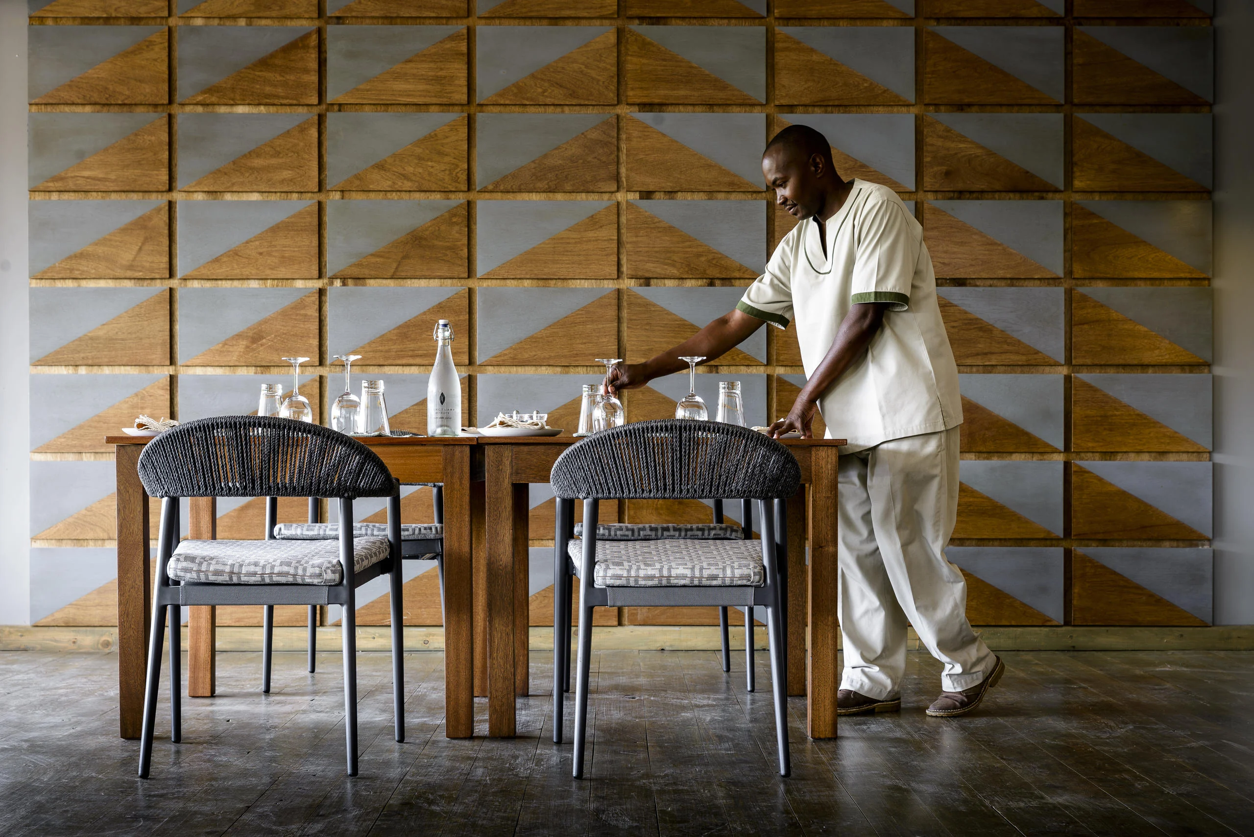 A member of staff laying a table in the dining room