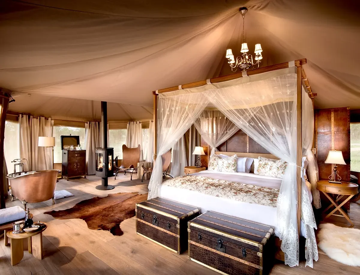 A tent bedroom with a draped four-poster bed