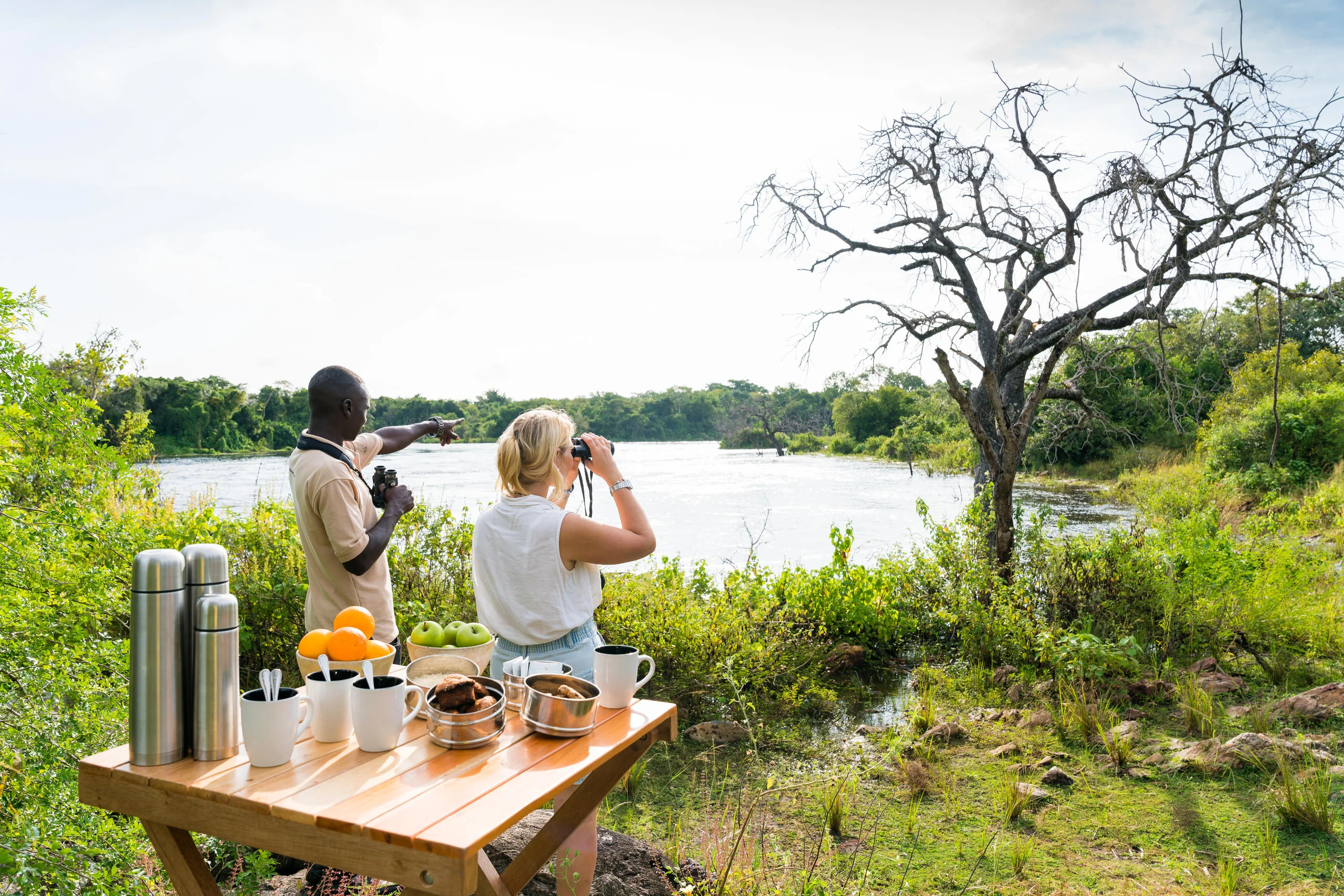 Two guests at a table above the river