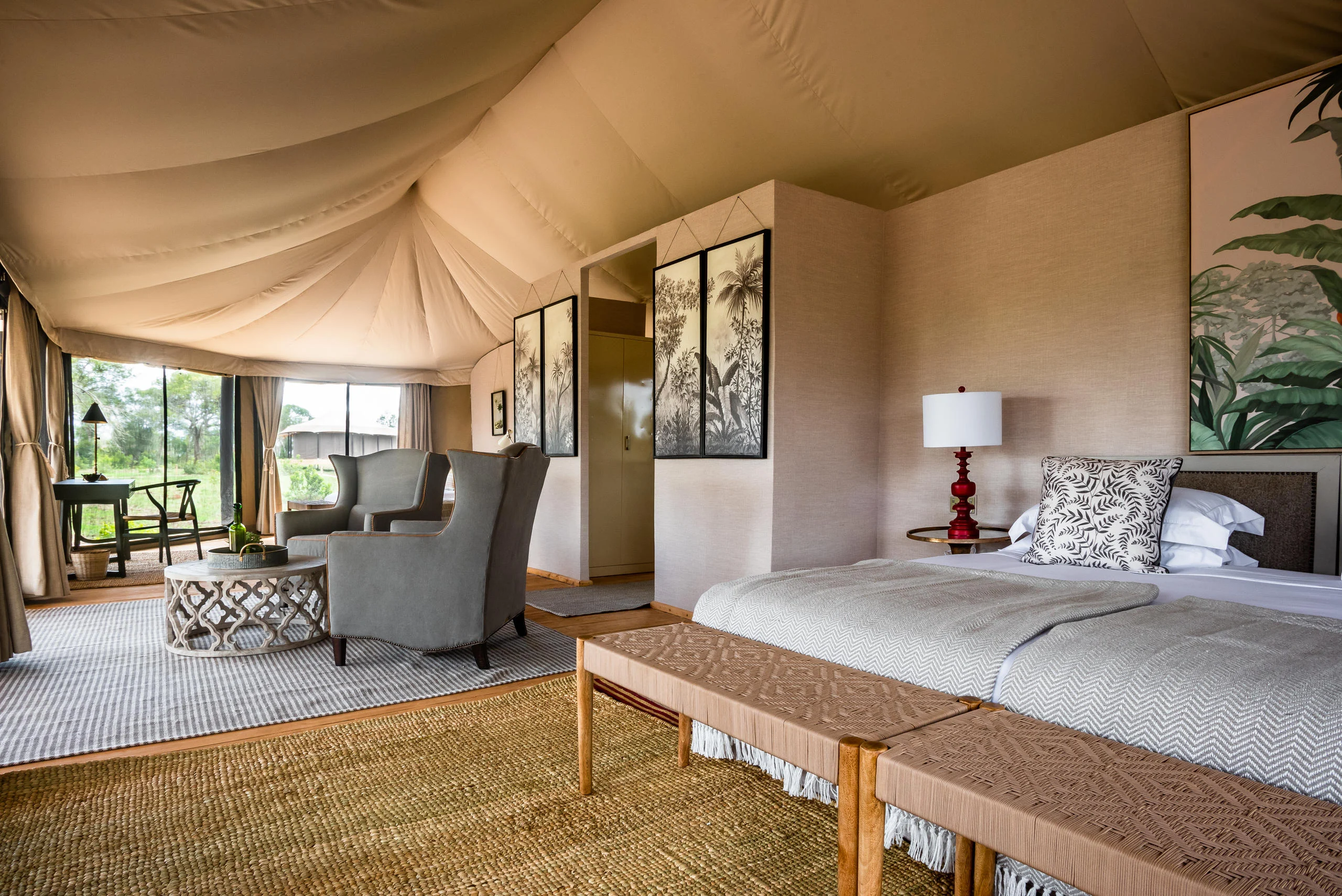 A tent bedroom with armchairs and a rug