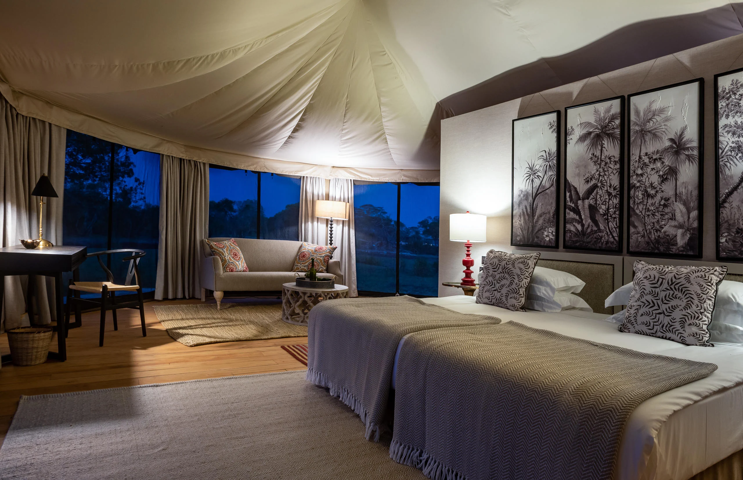 A tent bedroom at dusk with twin beds