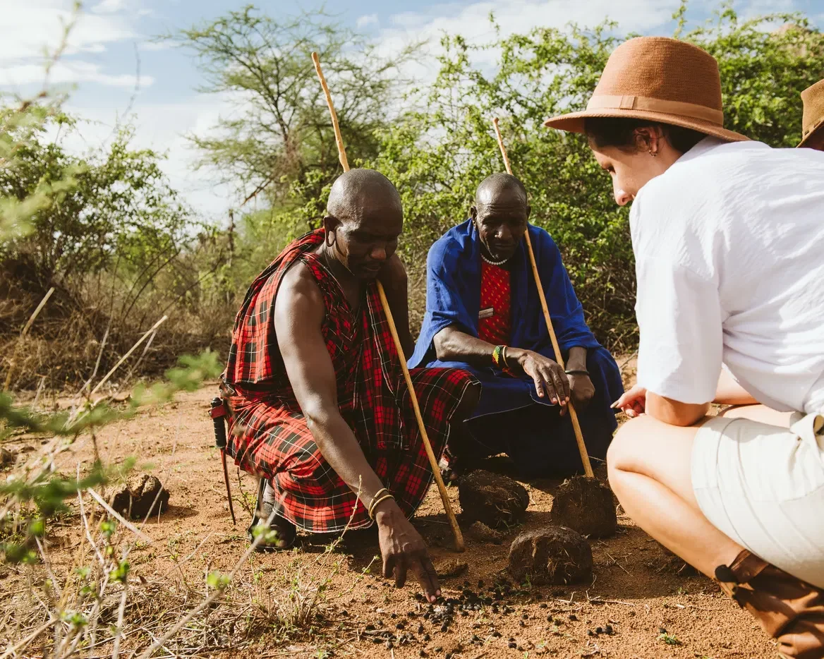 Guides showing a guest tracks on a walking safari
