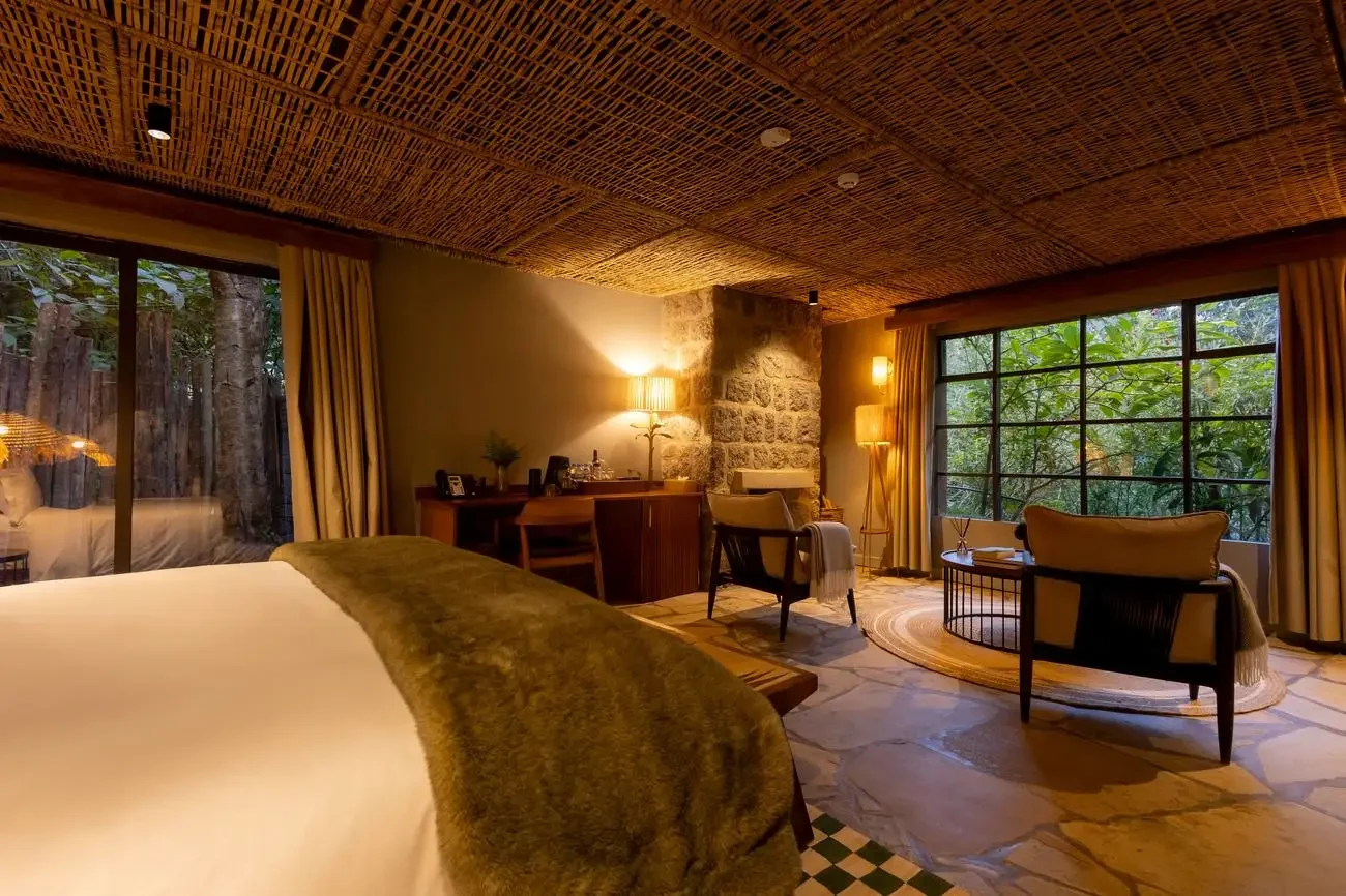 A bedroom with a green throw and a window onto the garden