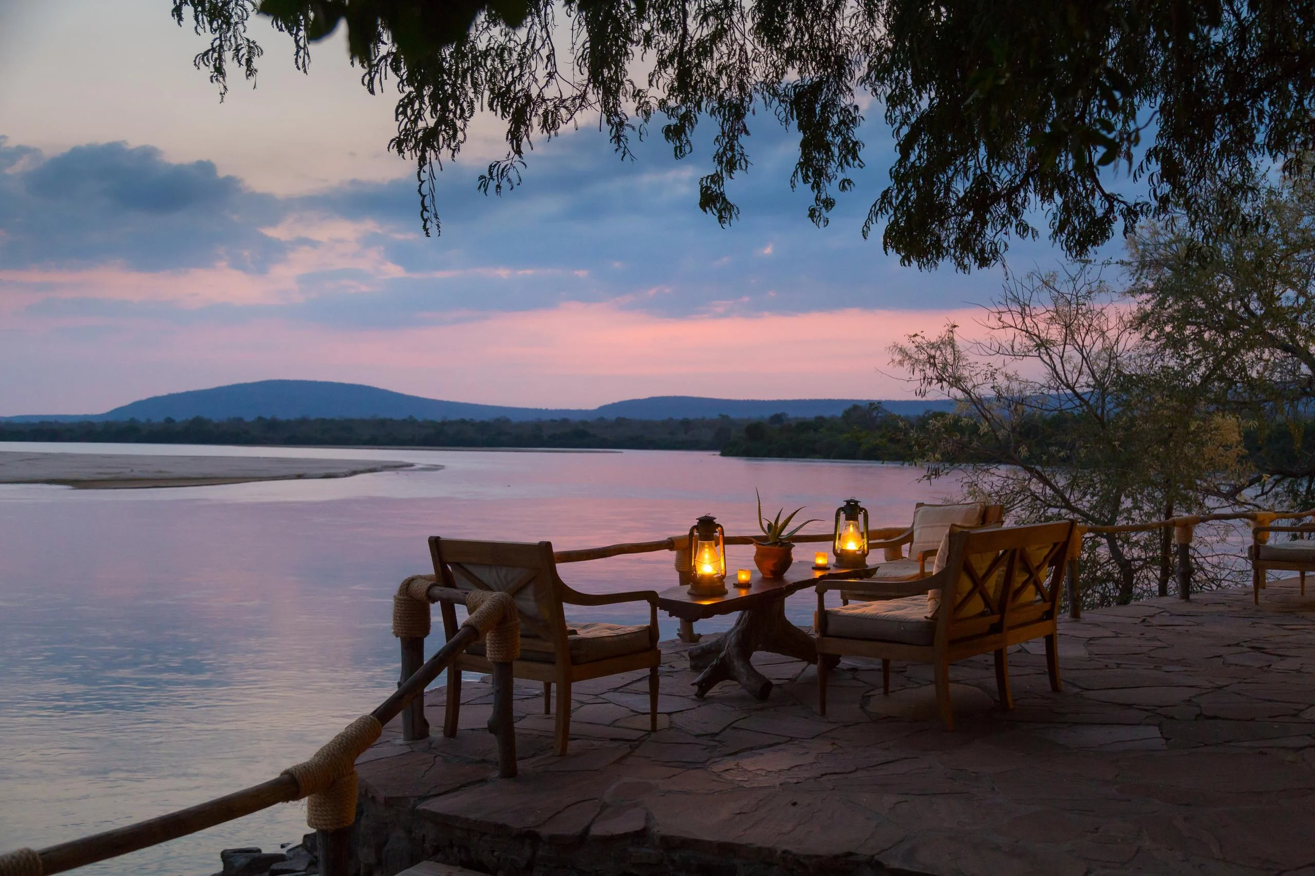 A table set beside the river at dusk