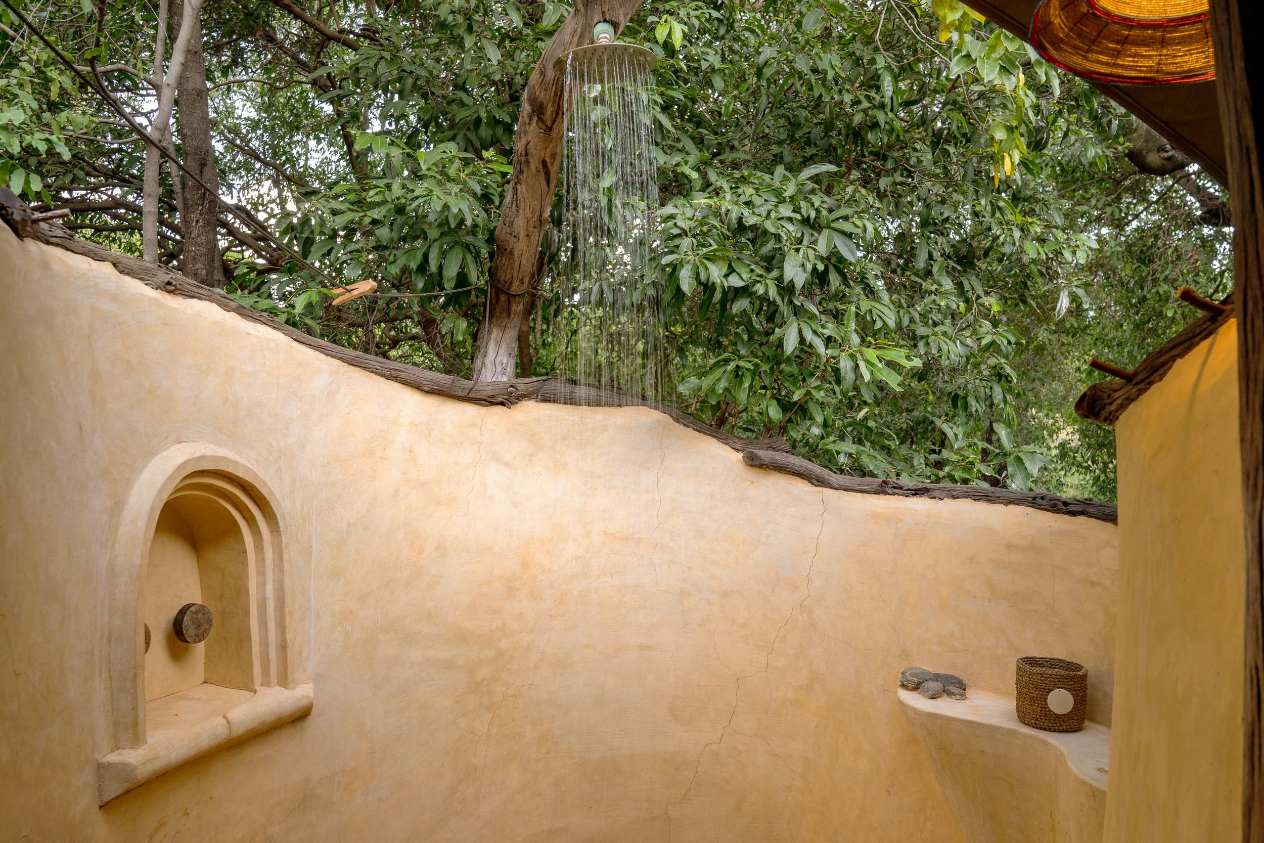 An open-air shower under the trees