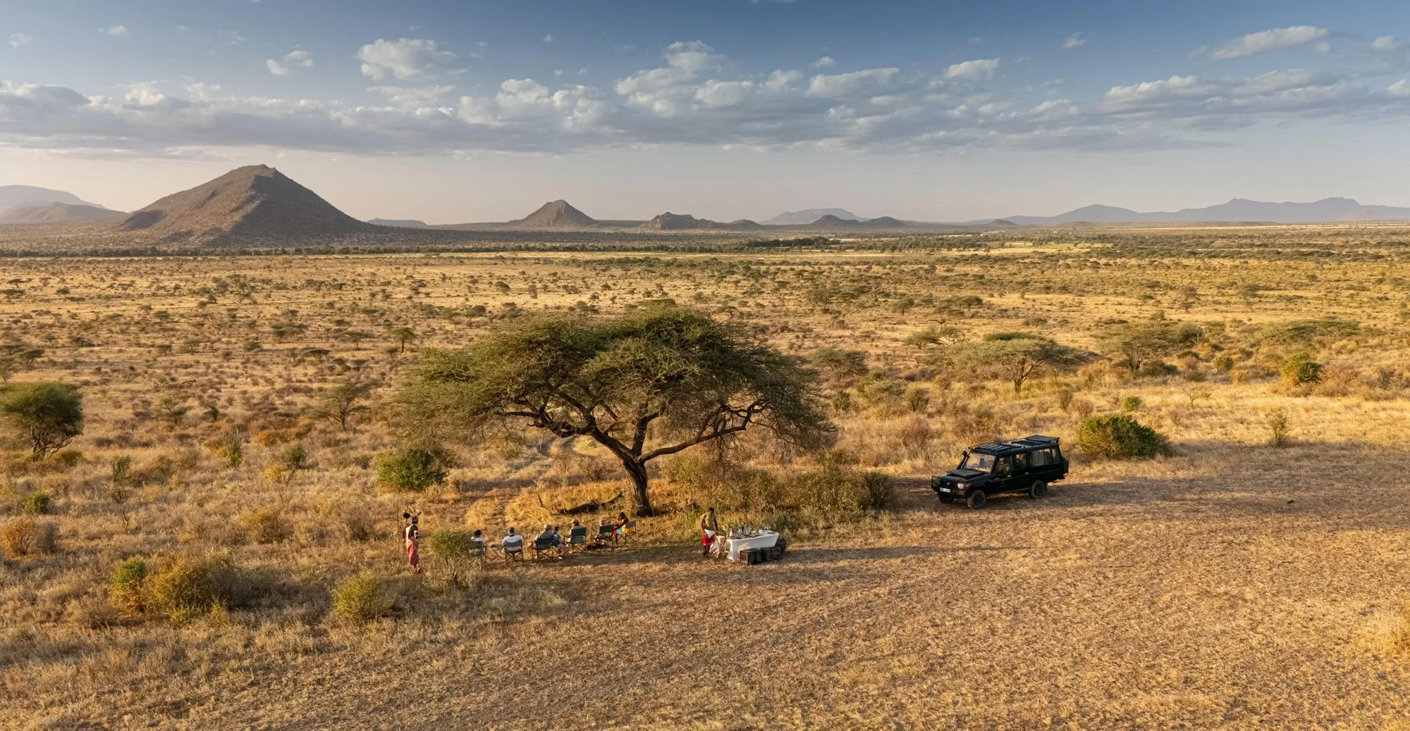 Sundowners under a tree with the hills beyond