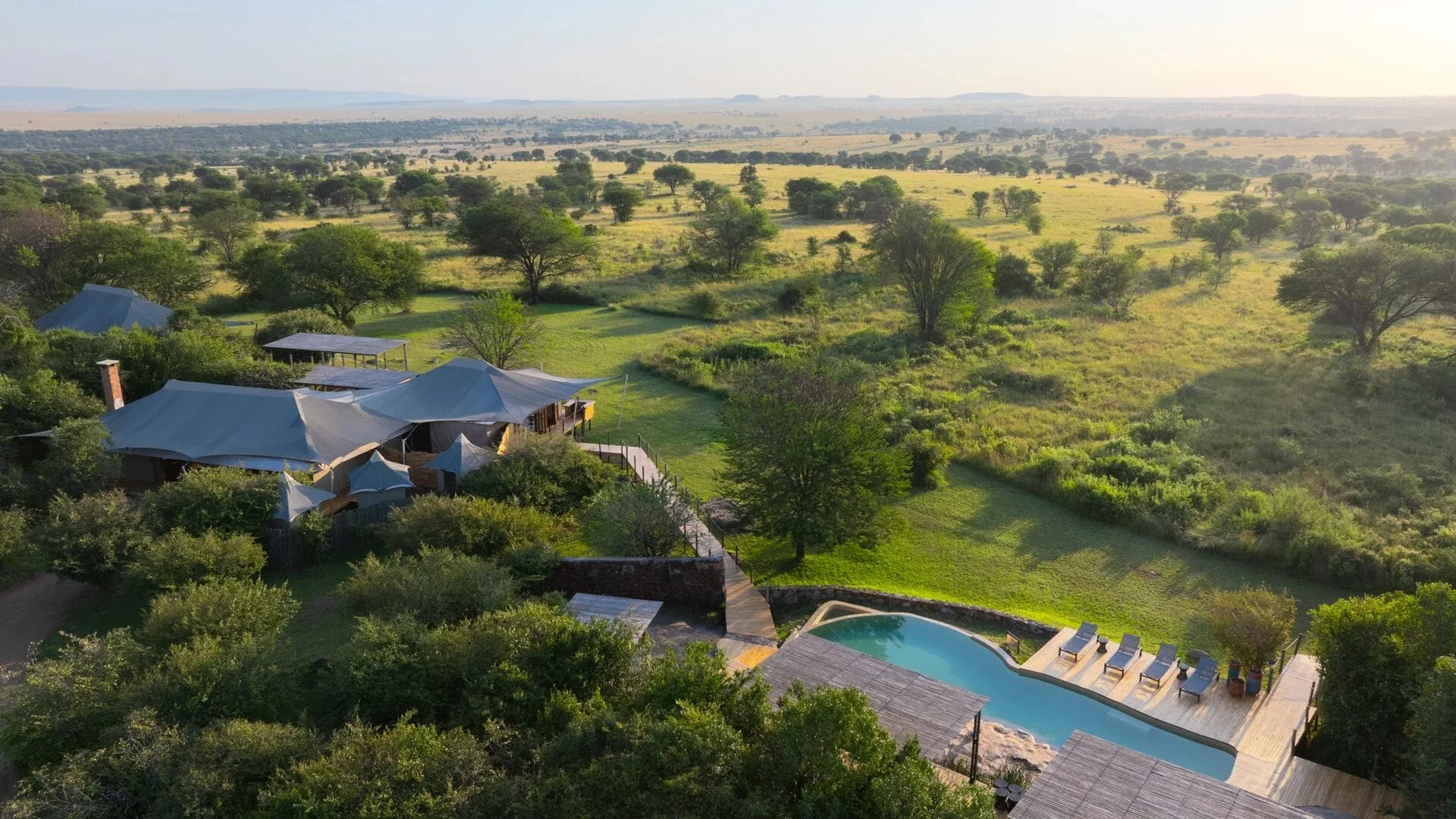The camp and its pool on the green plains, from the air