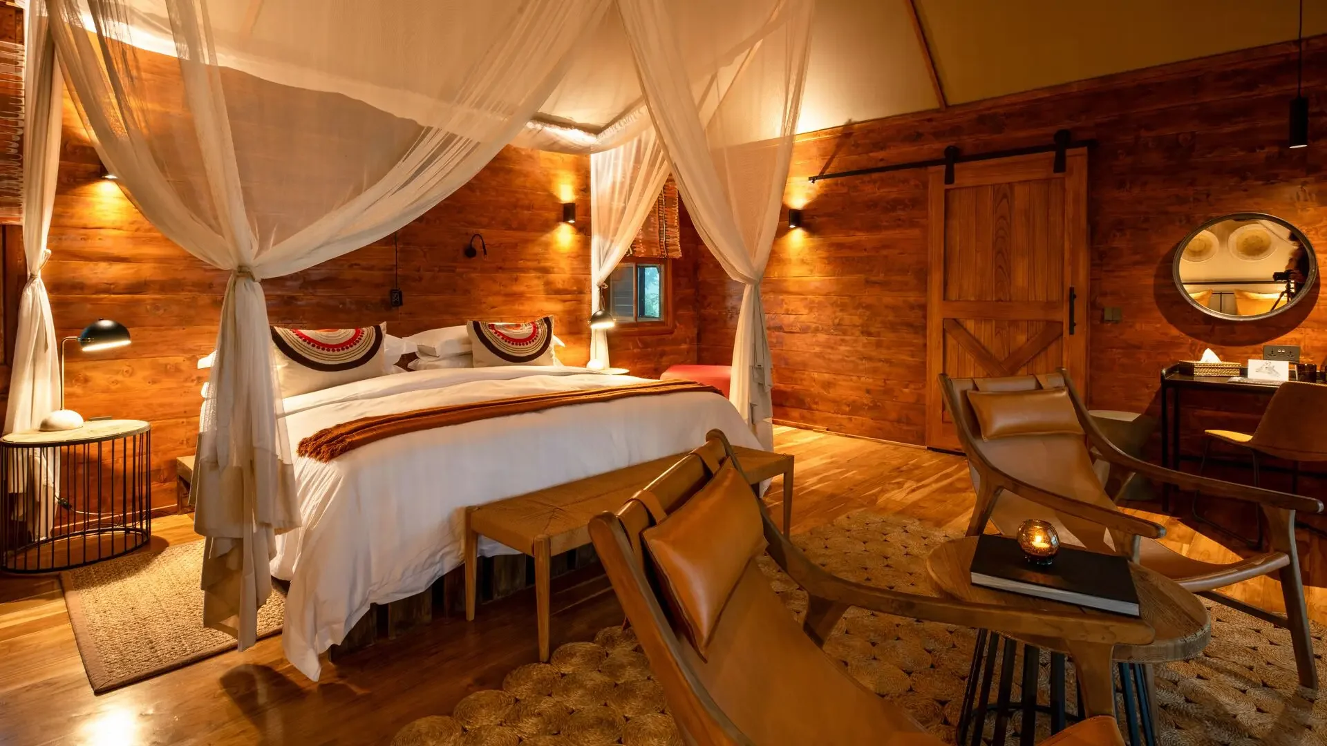 A bedroom with a draped bed and timber walls
