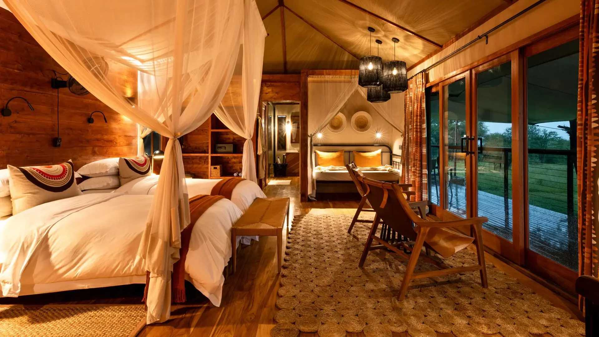 A bedroom with a draped bed and doors onto the deck