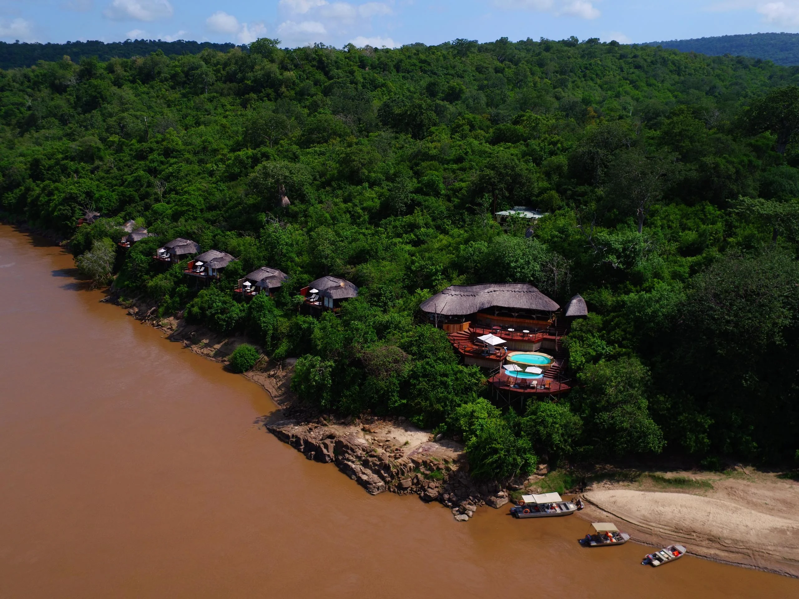 The lodge on the forested bank of the river, from the air